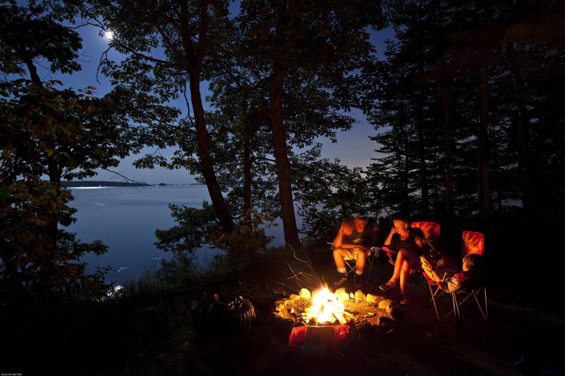 A family around a campfire by evening, Maine, USA