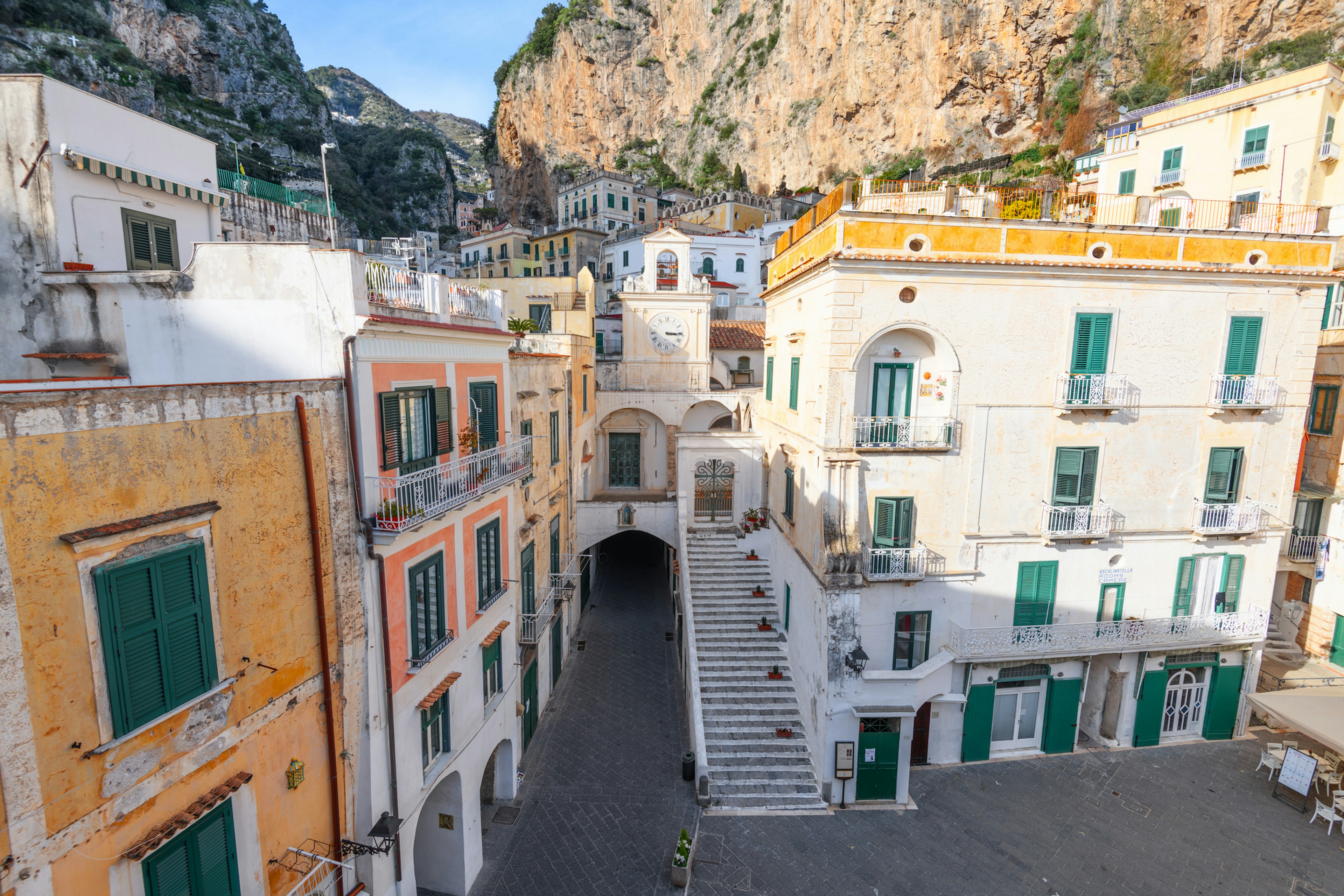 A white church building tucked in among narrow alleyways of a small town