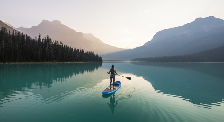 A young woman paddleboarding on Emerald Lake at sunrise in Yoho National Park.
1599827836