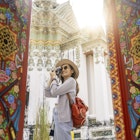 A woman taking a picture of Wat Pho in Bangkok