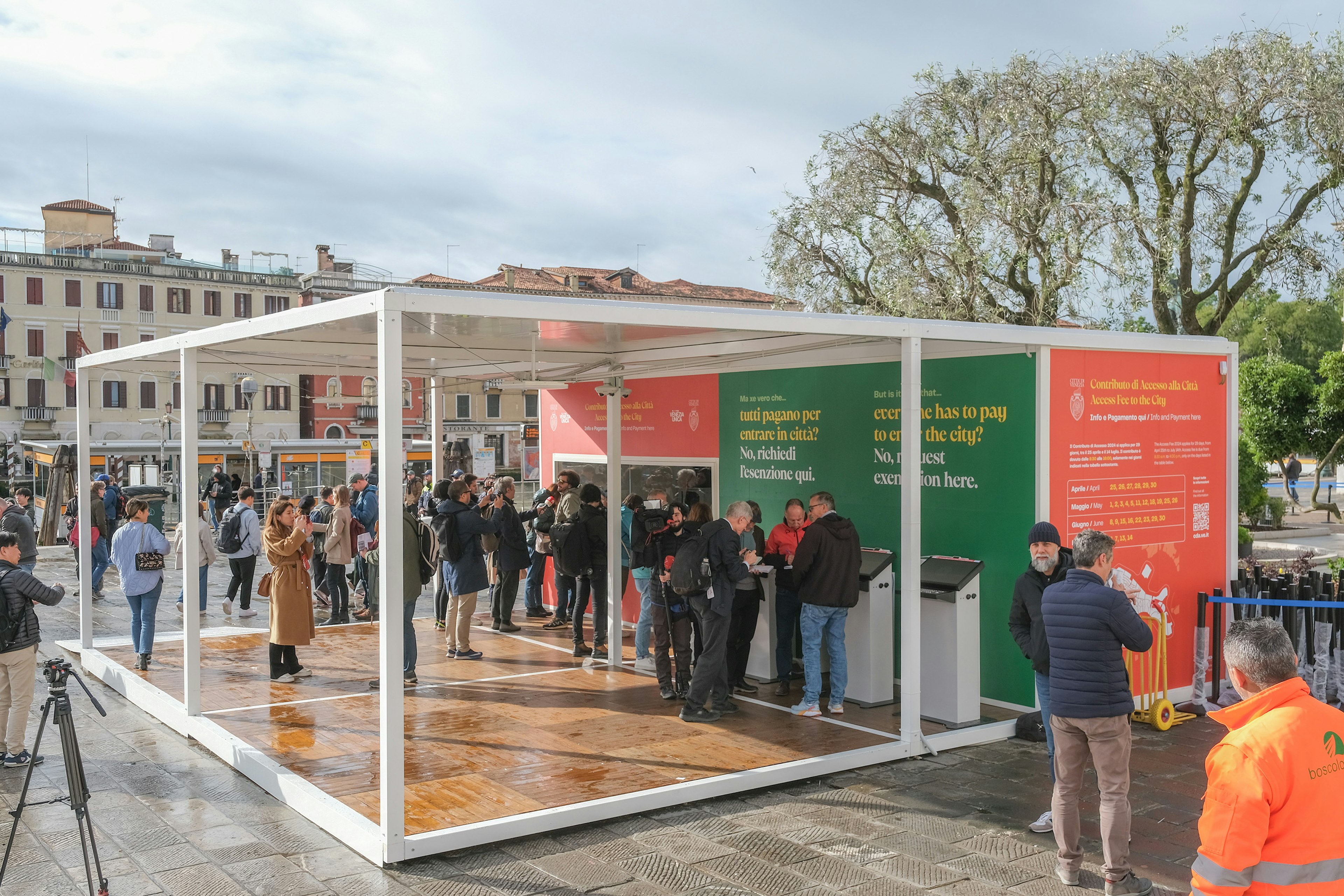 People queue in a makeshift office to purchase entry tickets to Venice