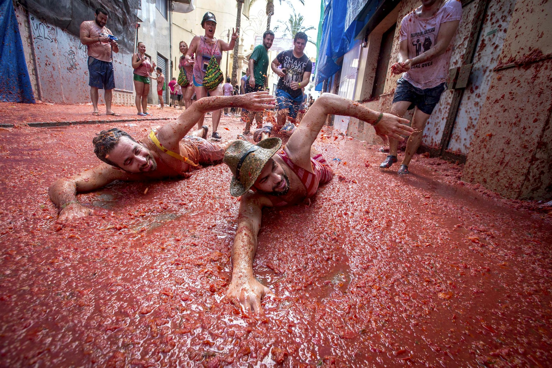 Revelers mock a swim in tomato pulp at the annual La Tomatina tomato-throwing festival, Buñol, Spain