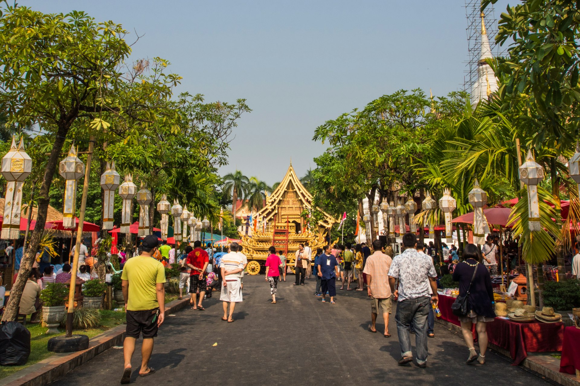 Many people walking down a street towards Wat Phra Sing in Chiang Mai's Old City during the Songkran festival