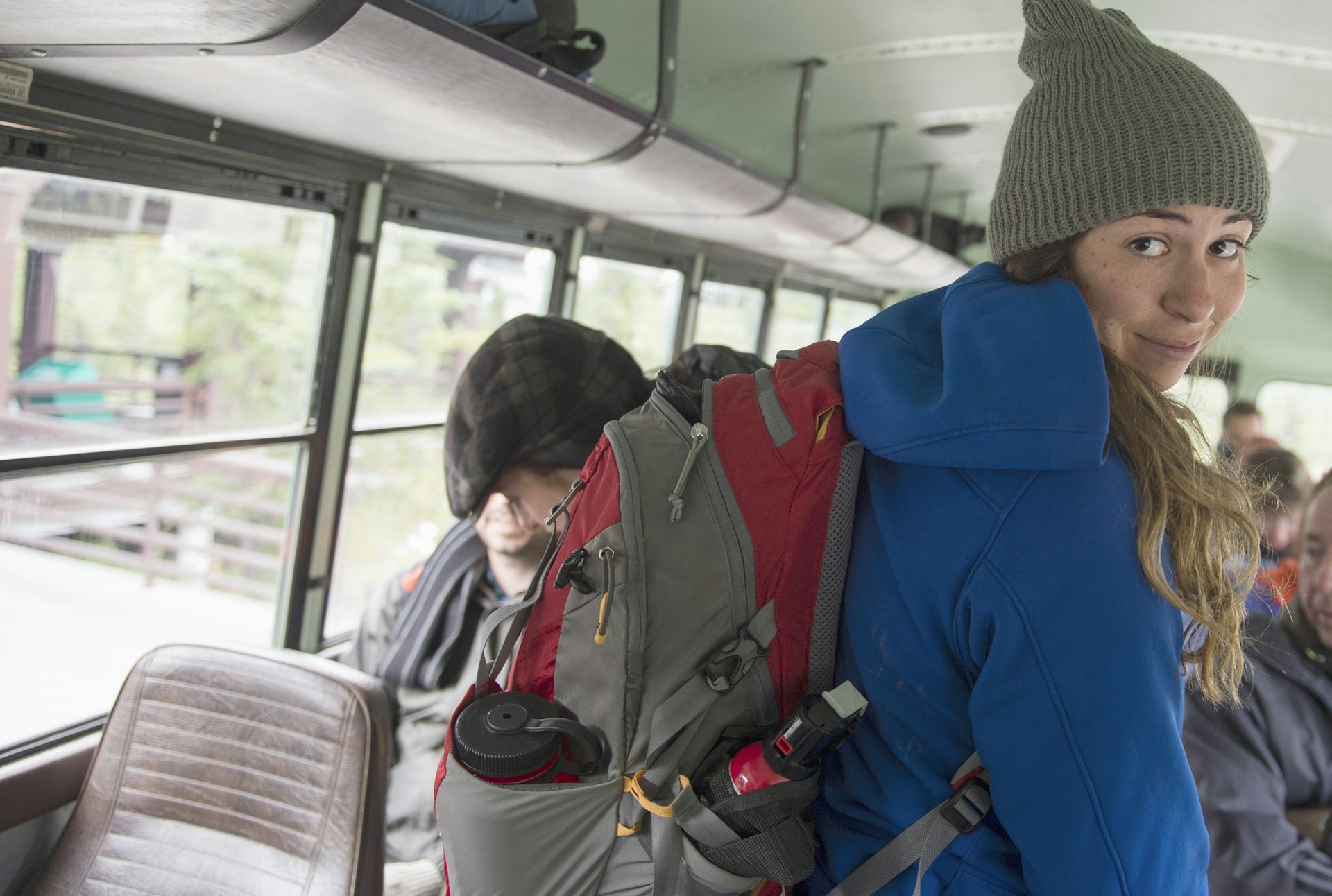 A young woman with a backpack on the bus in Denali National Park, Alaska