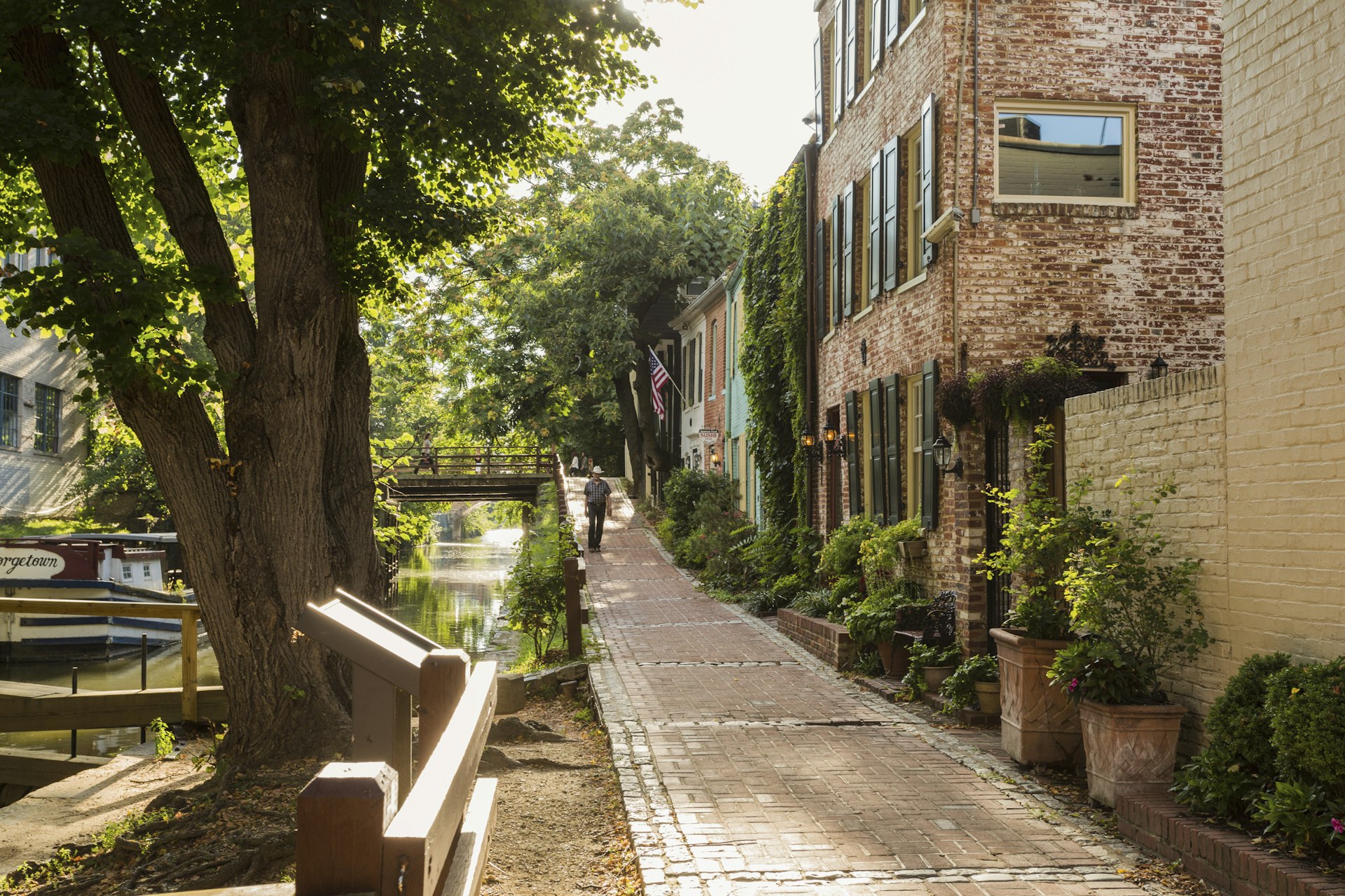 A man walks by historic buildings along the C&O Canal in Georgetown, Washington, DC, USA