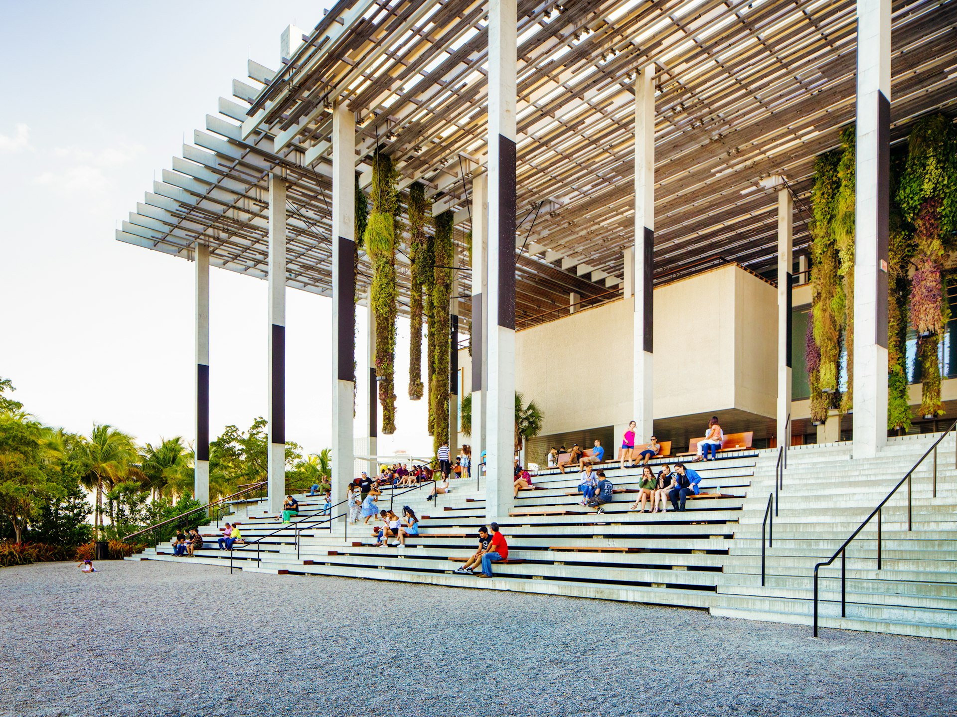 People are sitting on or walking up the stairs of the Pérez Art Museum in Miami