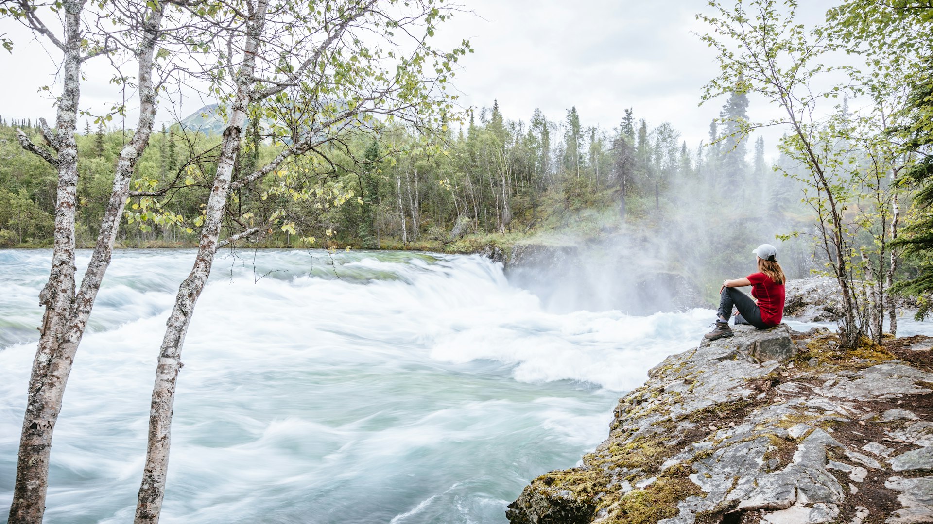Woman admires the view of Tanalian Falls in Lake Clark National Park and Preserve, Alaska