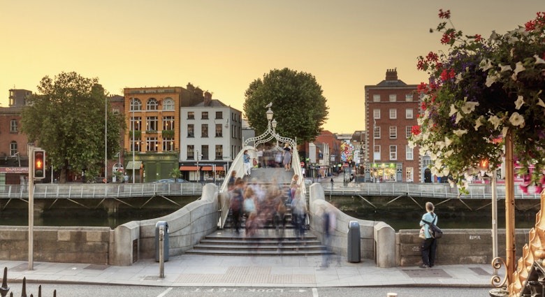 People walking across the Ha'penny bridge in Dublin City at sunset
865636254