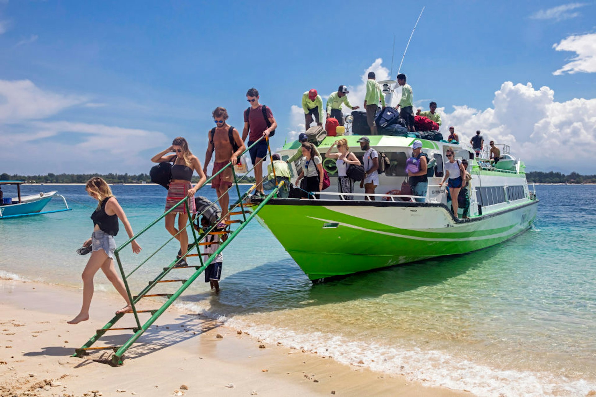 Western tourists debarking from speedboat - fast boat on the island Gili Trawangan, largest of Lombok's Gili Islands, Indonesia.