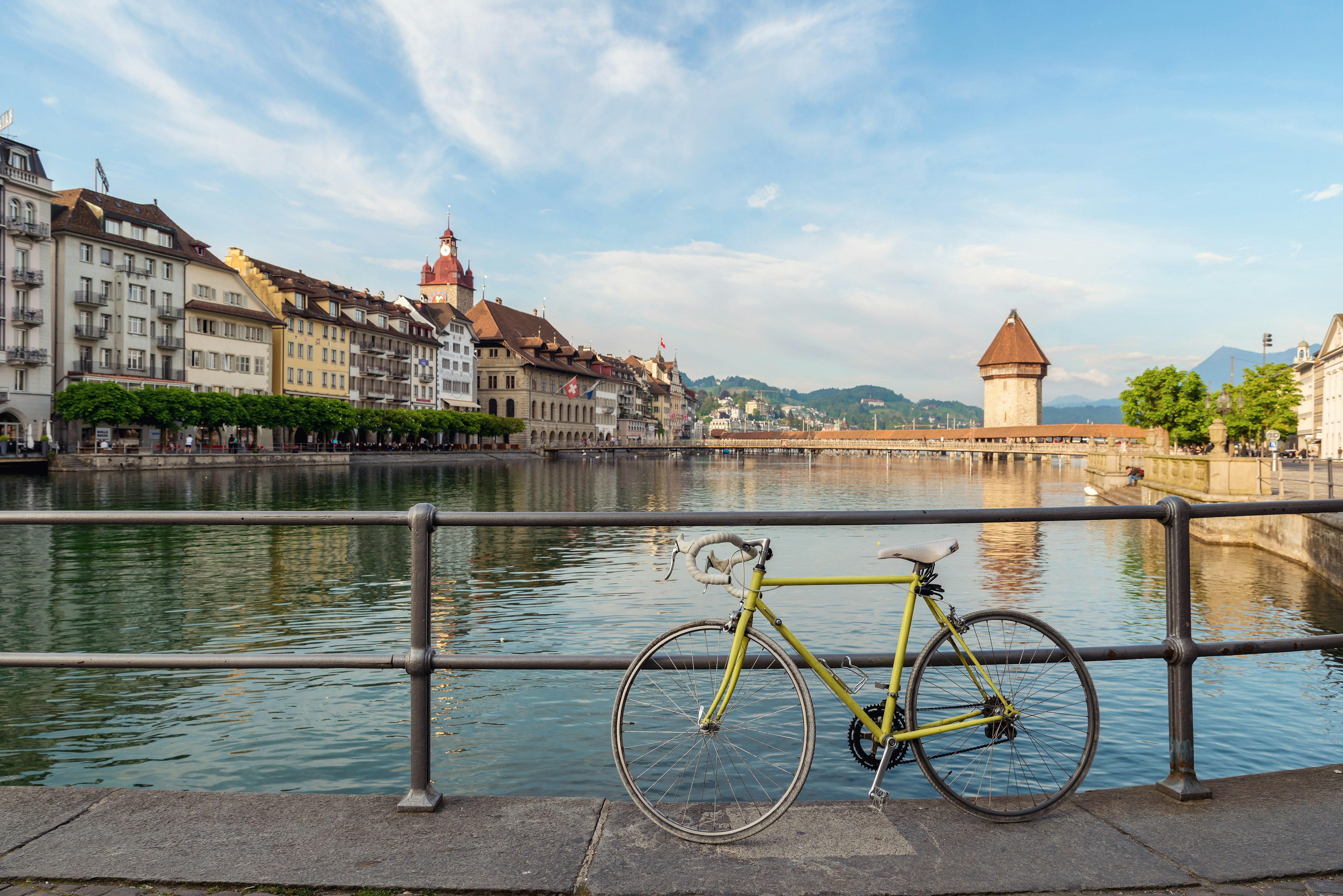 Bicycle in historic city center of Lucerne with famous Chapel Bridge with blue sky and clouds in Lucerne, Switzerland