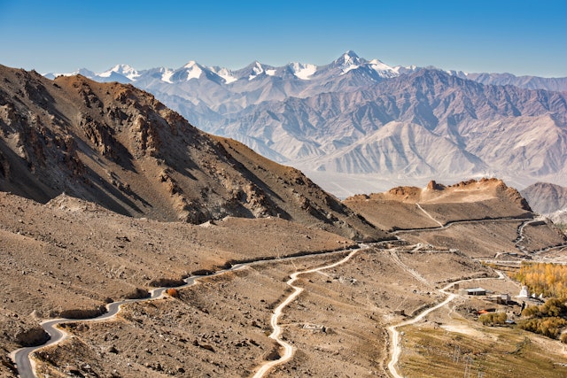 A mountain road weaves around bends and up and down hills