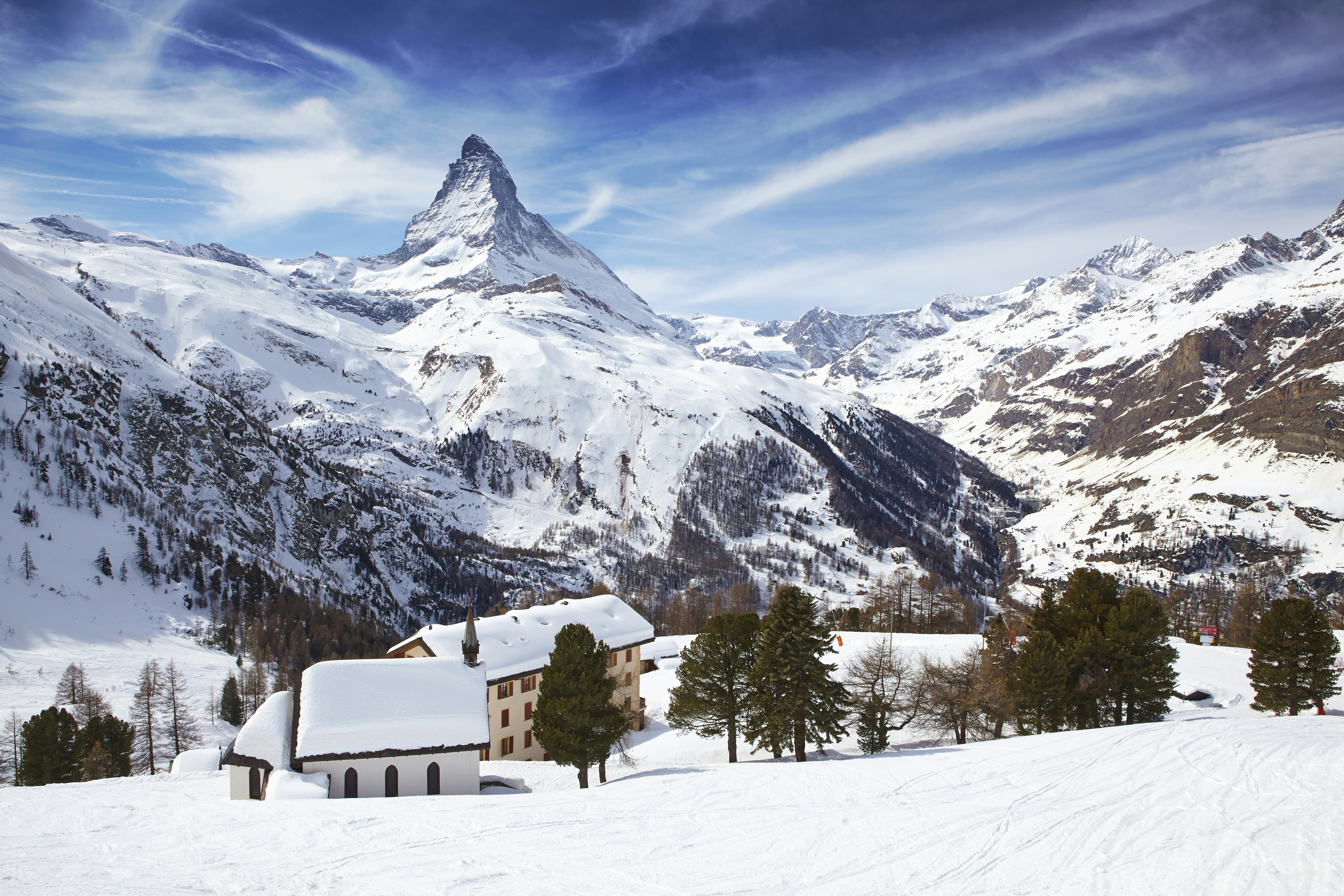 The Matterhorn rises over snowy rooftops near Zermatt in Switzerland.