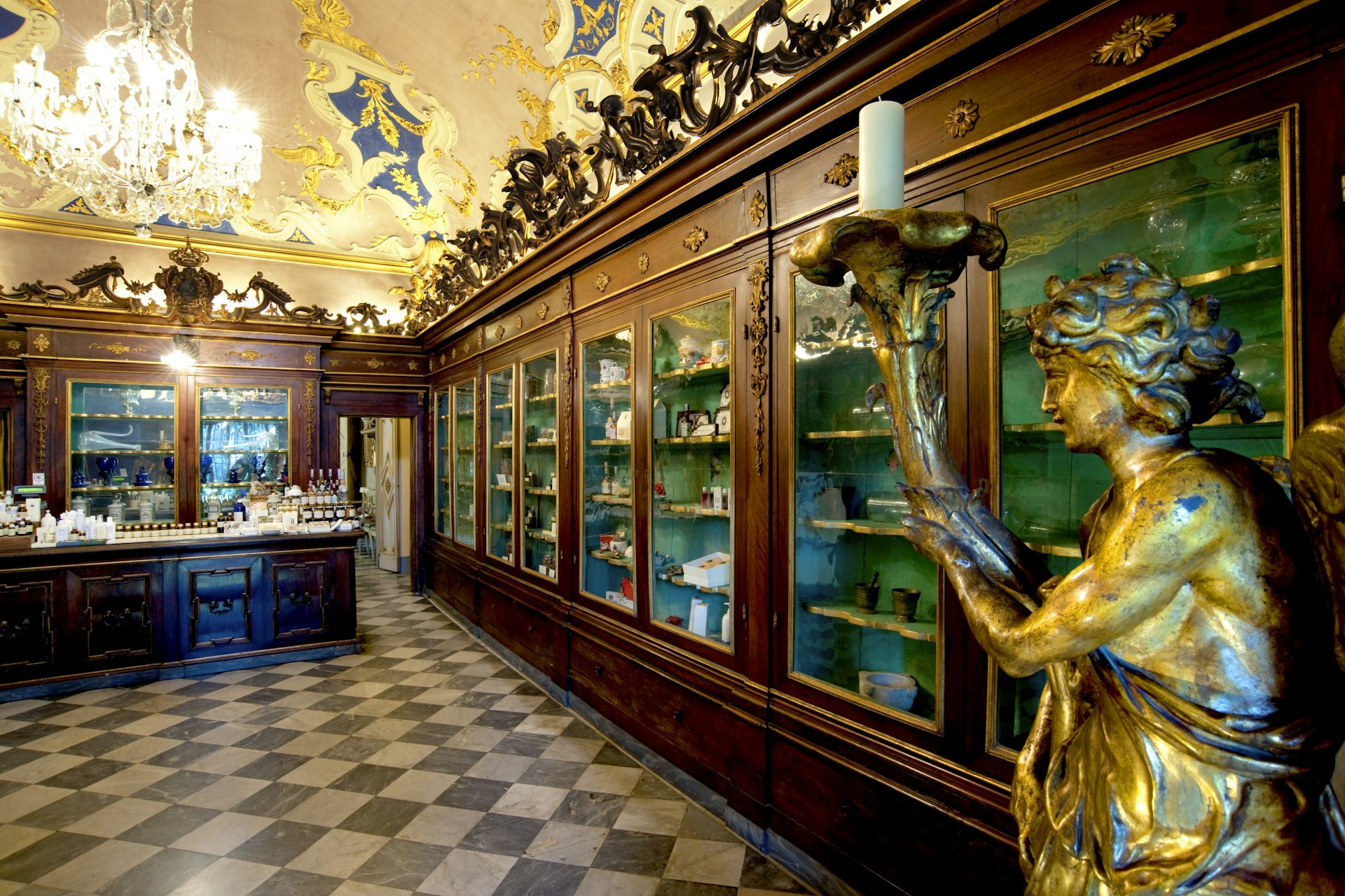 A large room lined with floor-to-ceiling wooden cabinets where antique apothecary items are on display