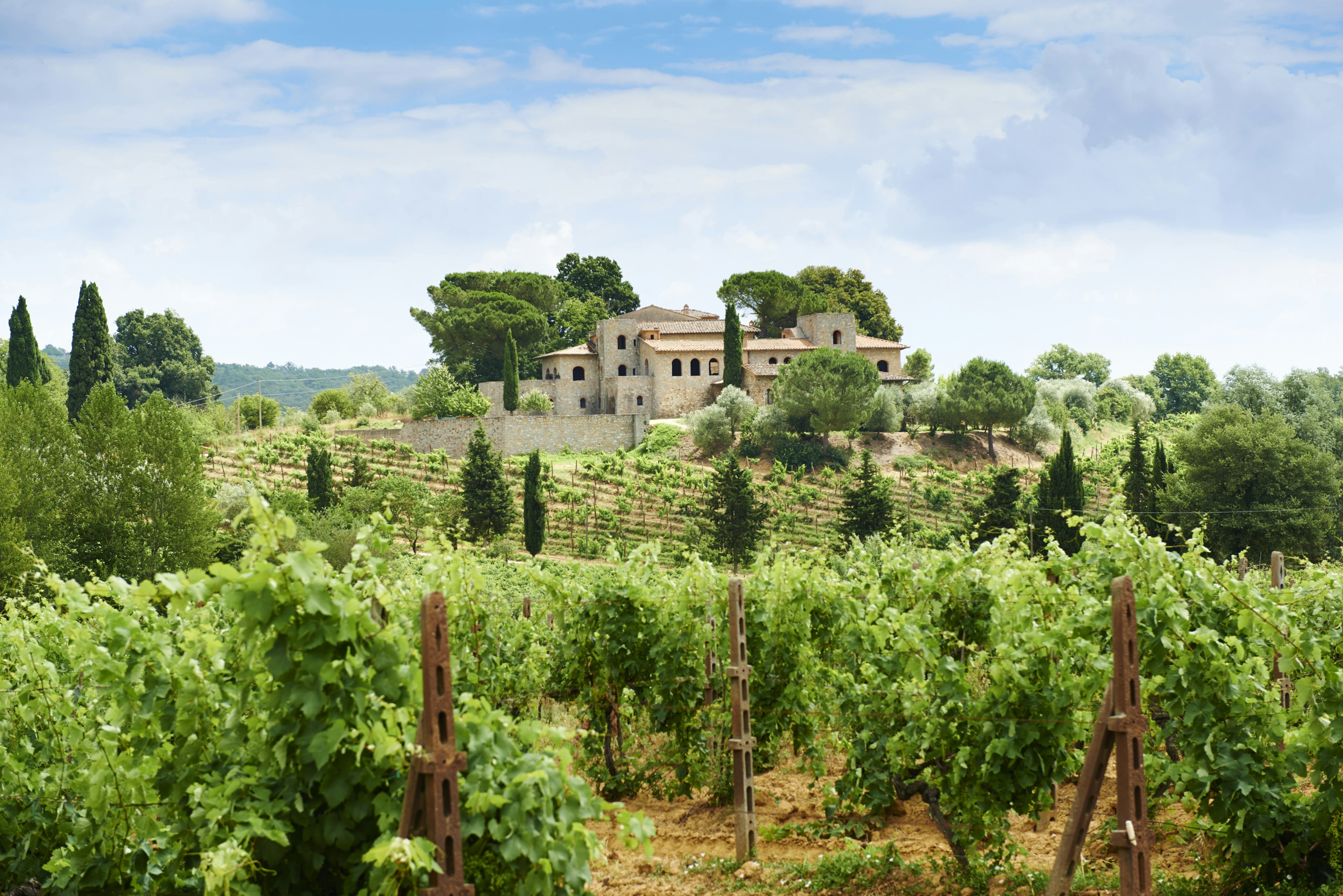 A sprawling villa is surrounded by trees and vineyards in Chianti, Tuscany