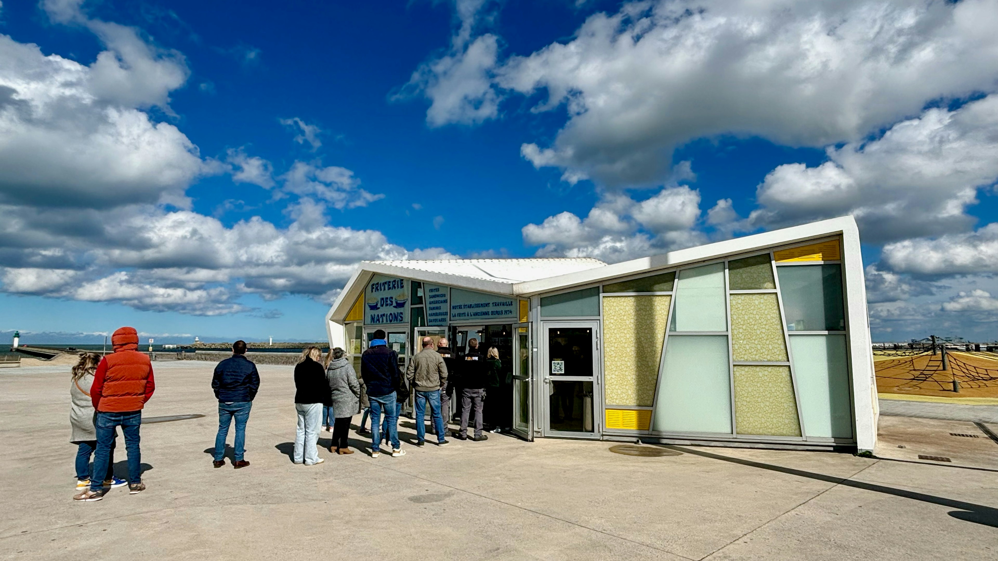 A line of people stretches outside a seaside kiosk selling food