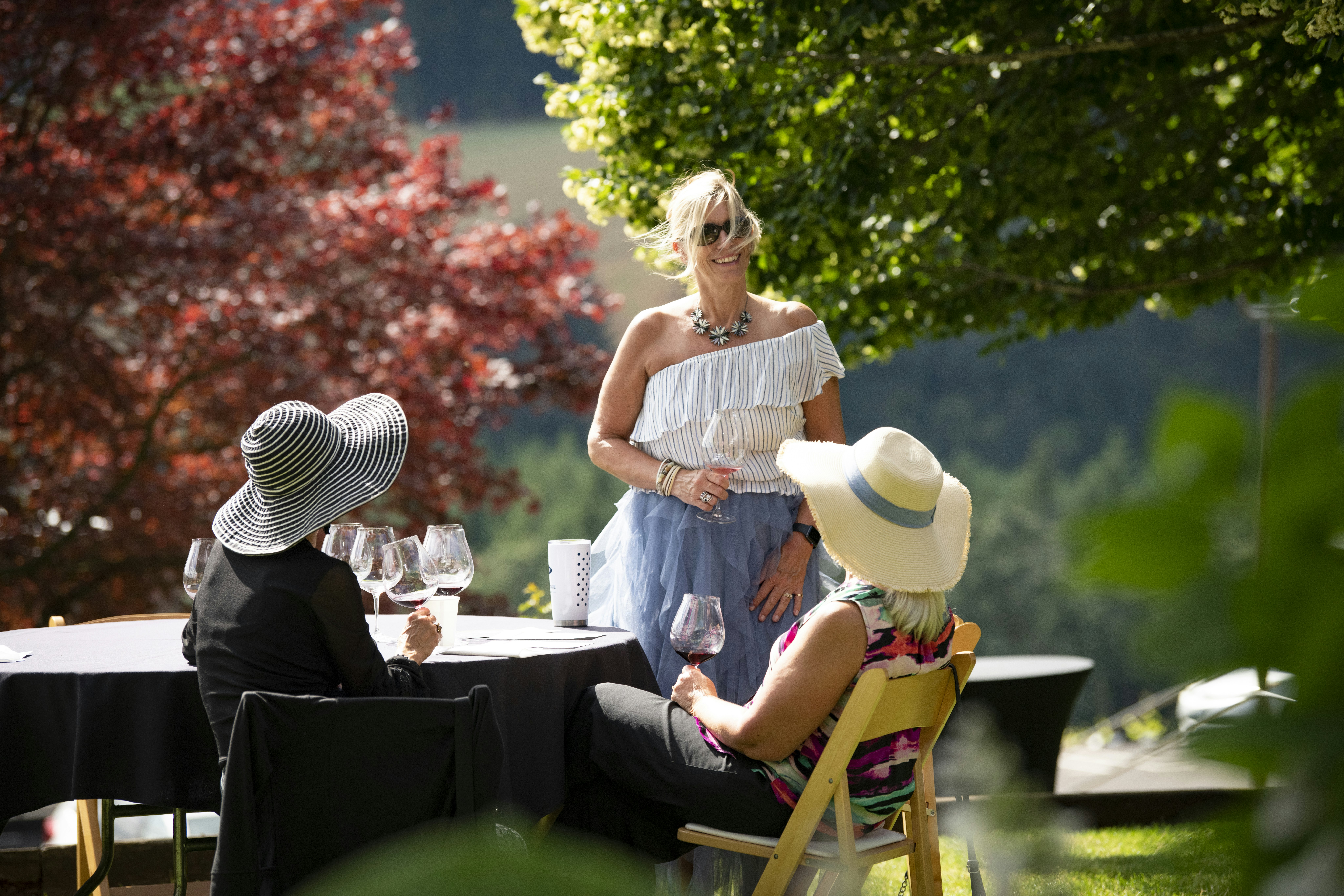 Women sip wine in at an outdoor table at Willamette Valley Vineyard, Willamette Valley, Oregon, USA