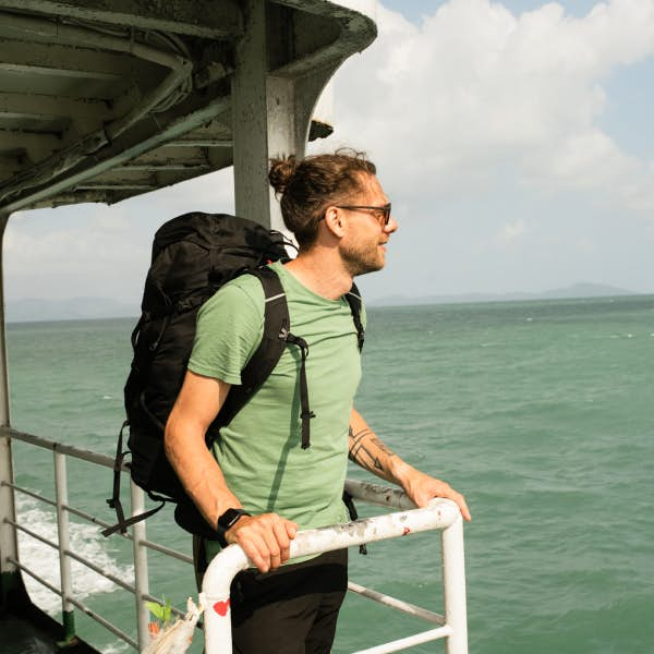 A backpacker looks out at the water from a ferry