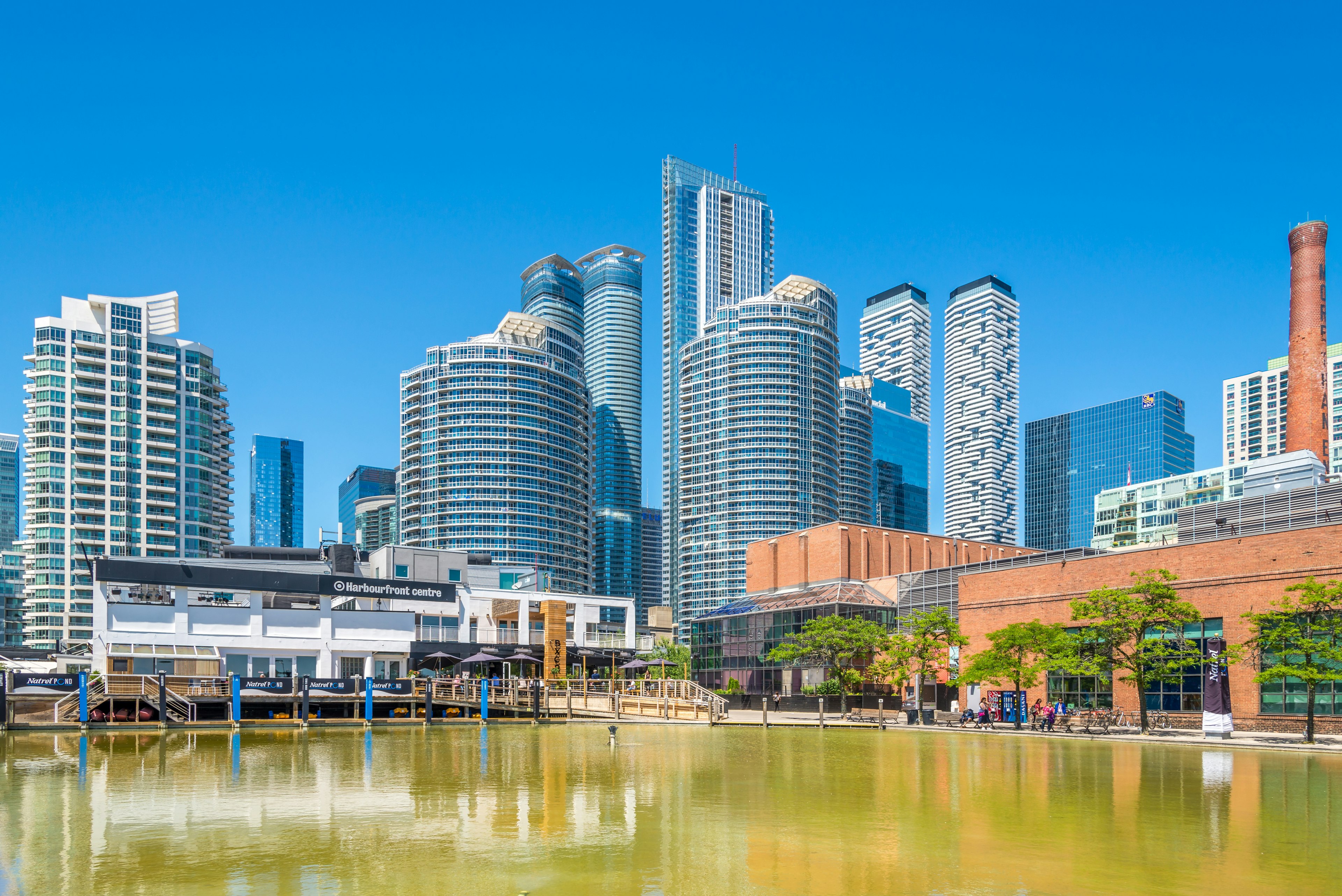 A waterway lined with cultural buildings overlooked by skyscrapers