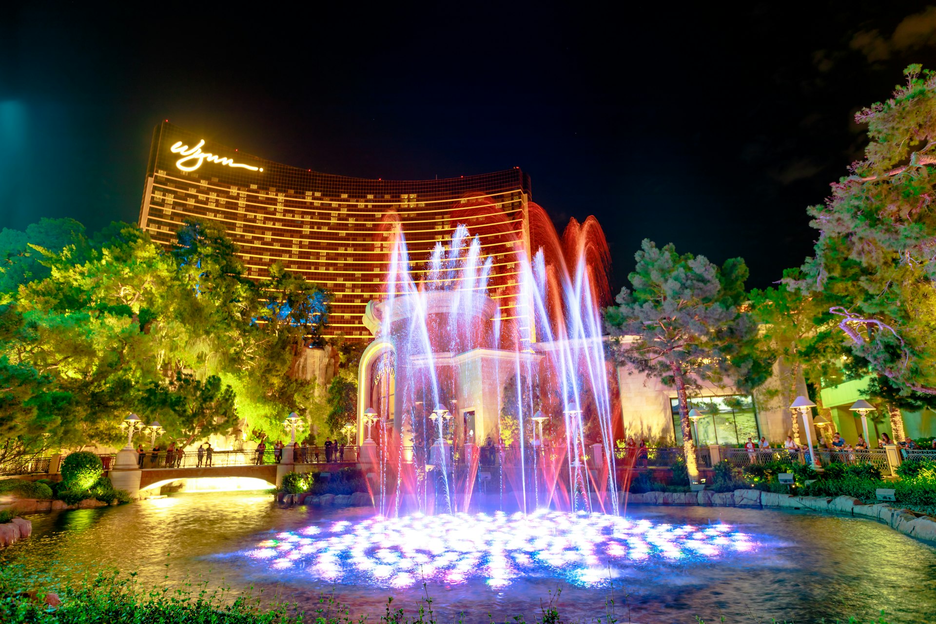 Fountains lit up at night in front of a casino