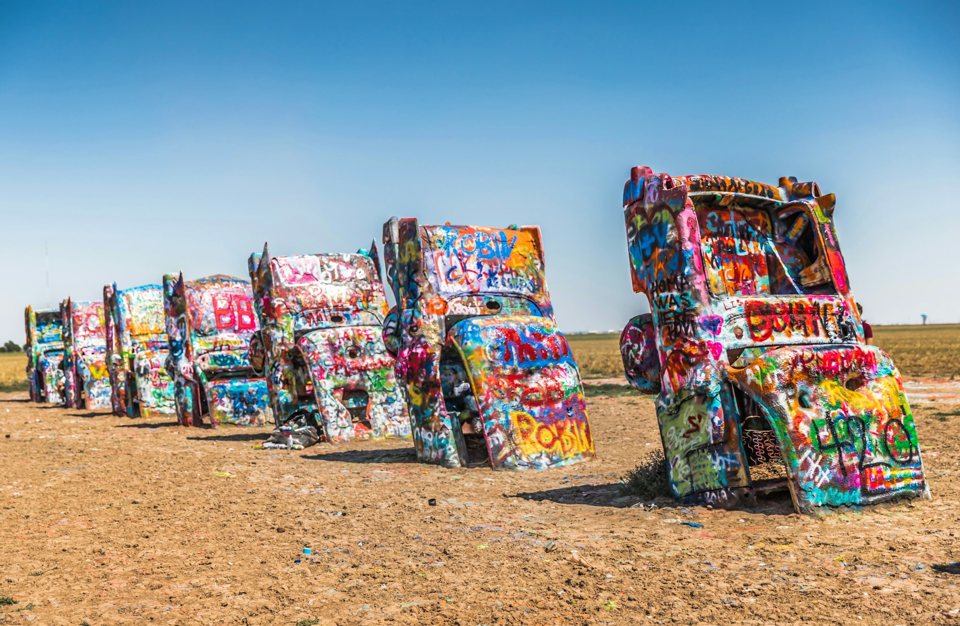 Brightly painted Cadillacs are buried head first in the ground at Cadillac Ranch, Amarillo, Texas, USA