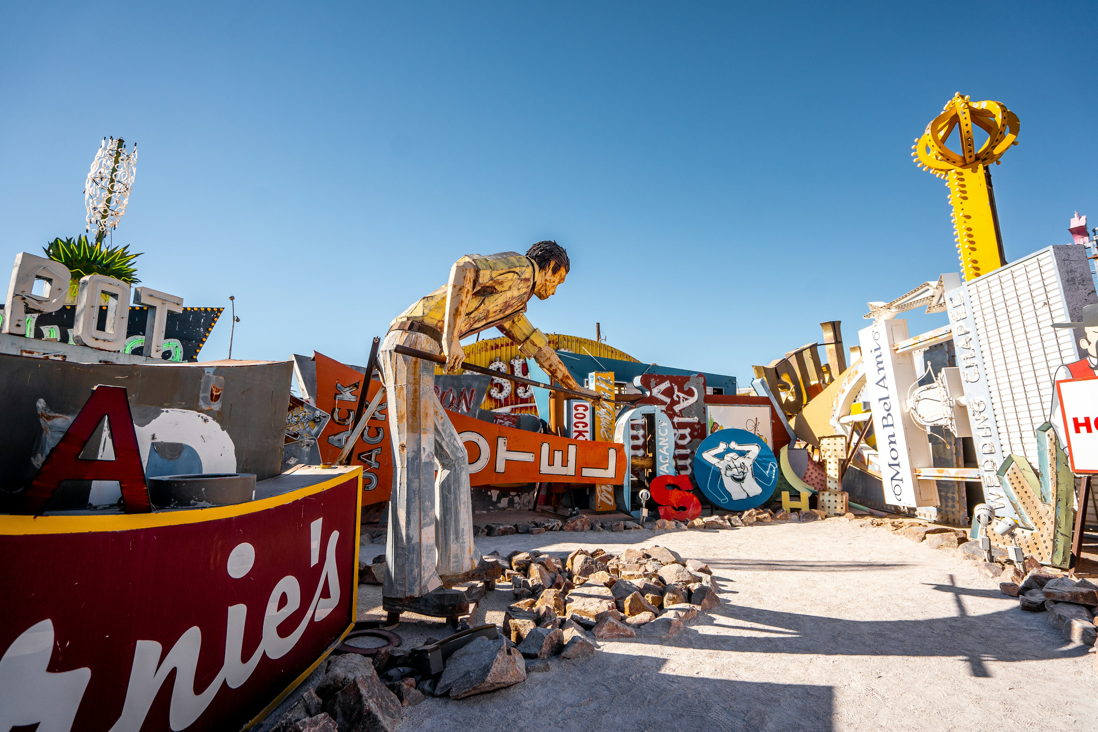 A stretch of neon signs and sculptures at an outside lot of a museum