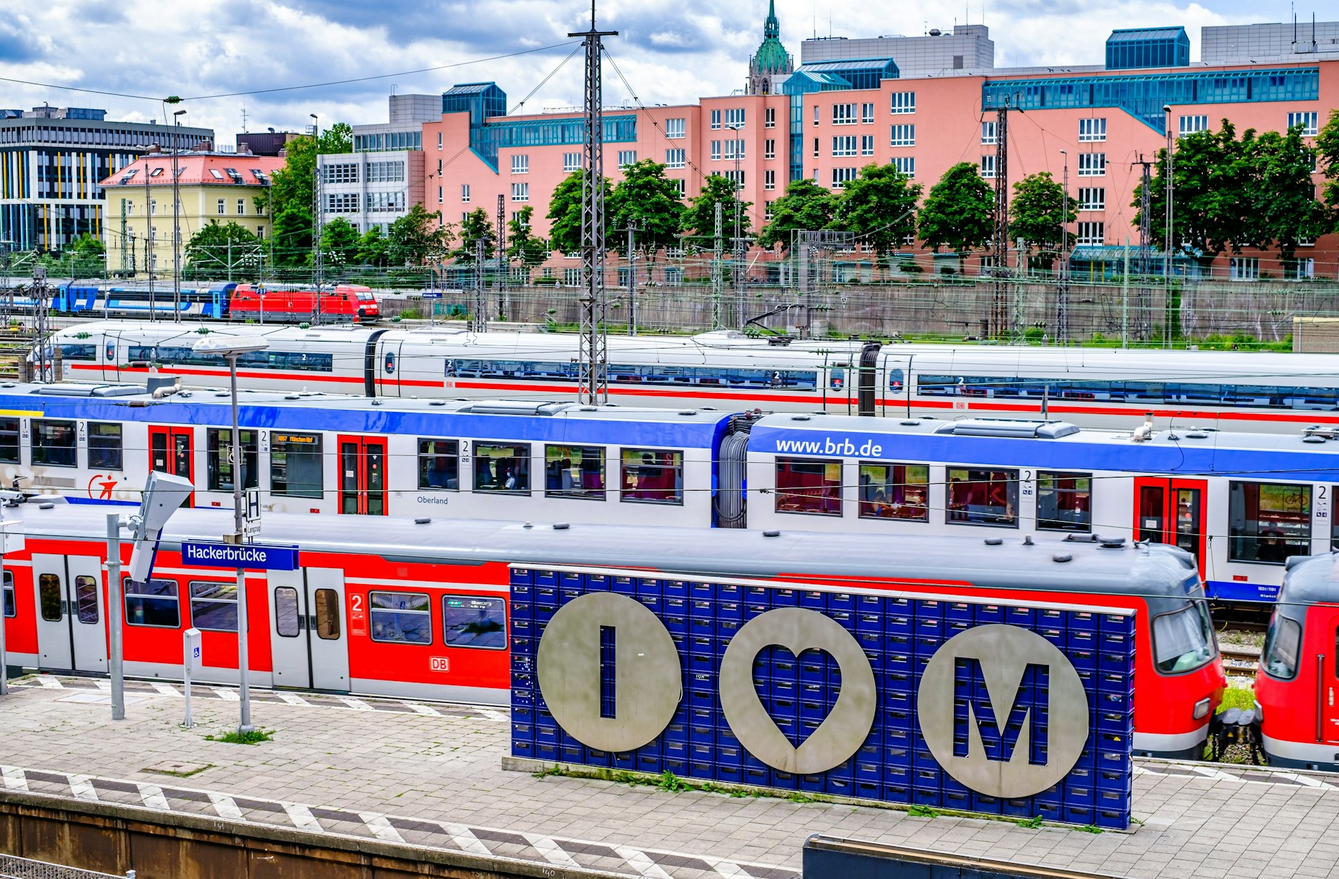 A sign saying "I heart M" at a busy train station