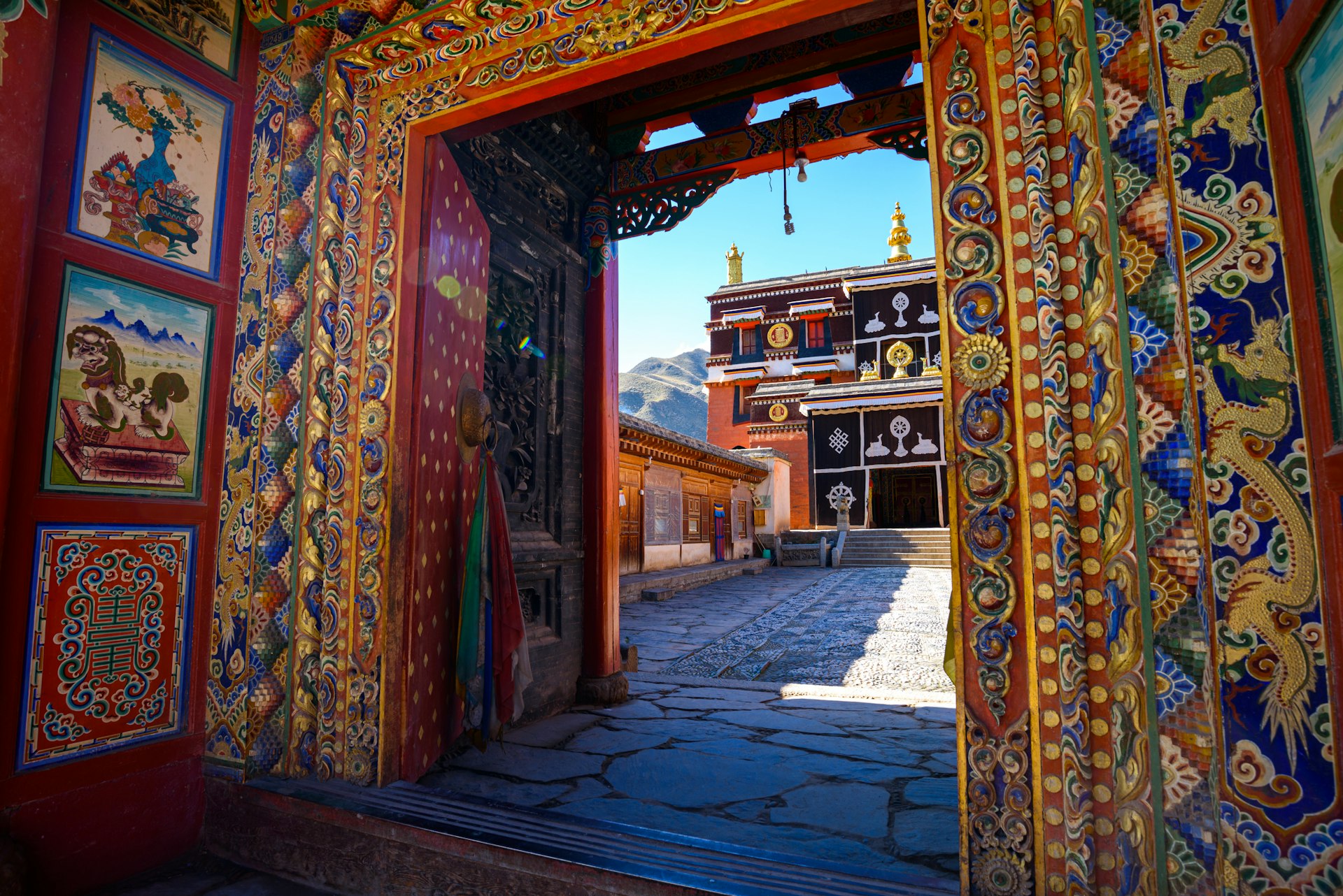 An ornate doorway in a temple complex with colorful patterns surrounding the frame