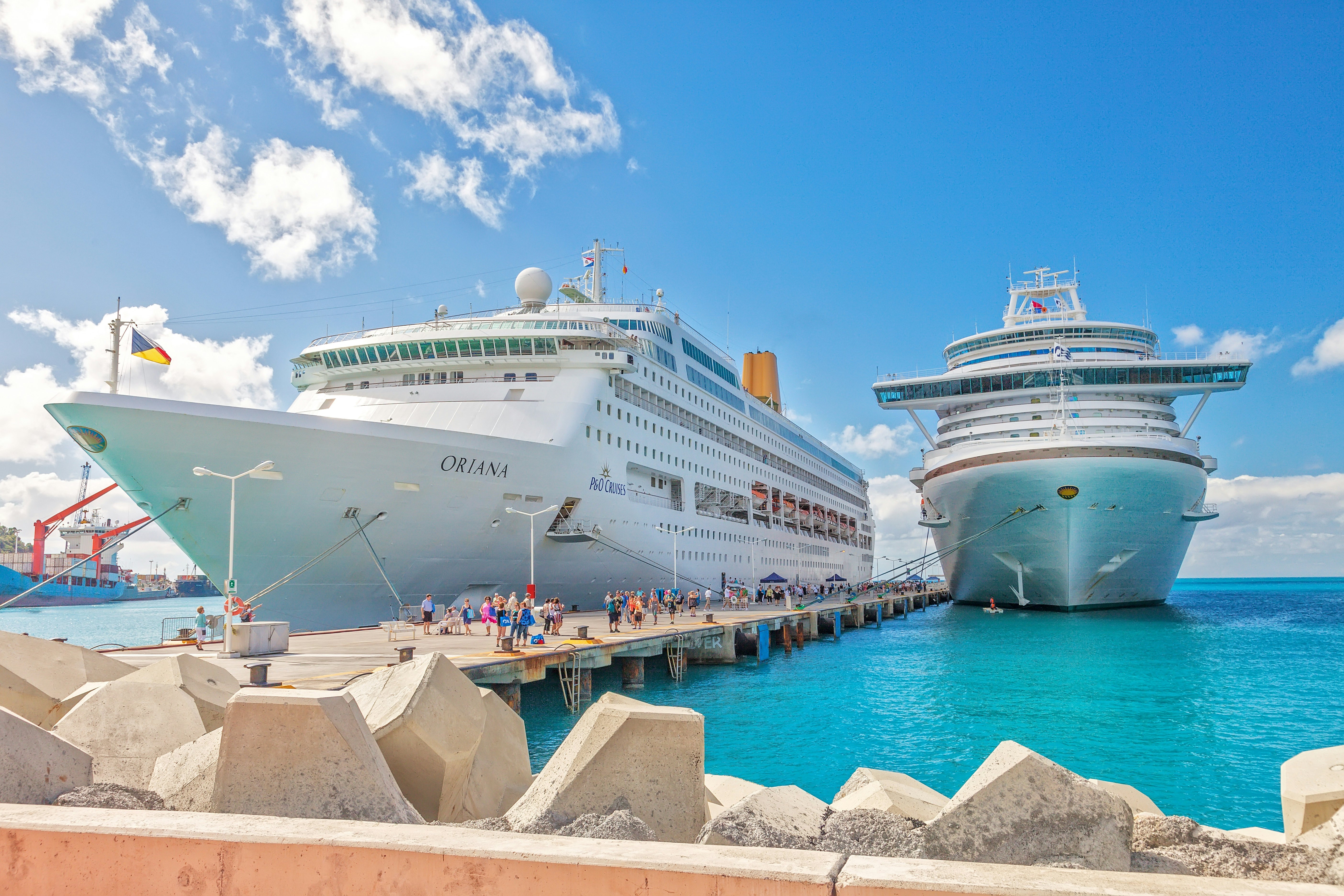 ruise ships docked at pier on the Dutch side of St. Maarten, with passengers walking on the pier