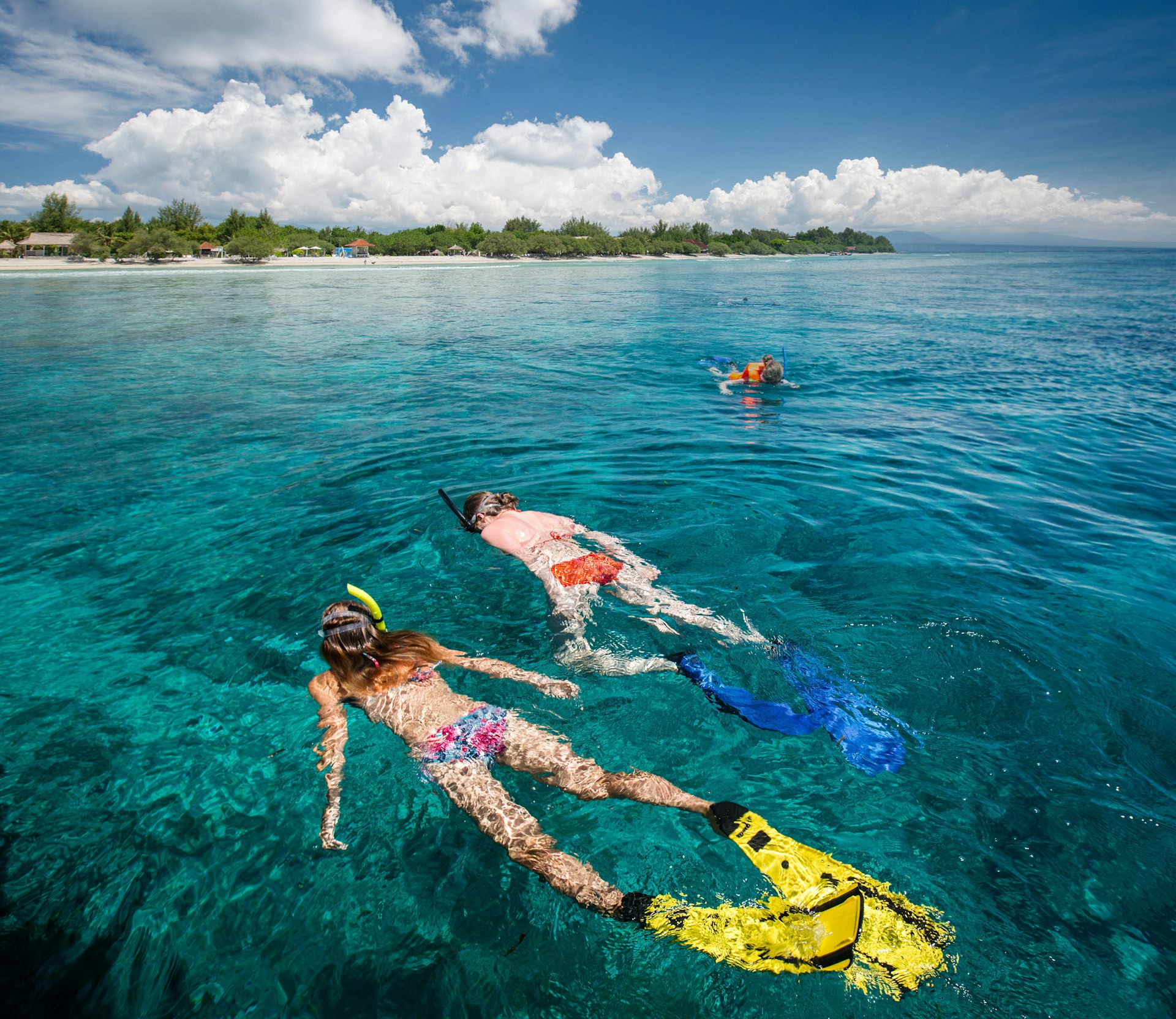 Two ladies snorkelling in the clear tropical sea near the island of Gili Trawangan, Indonesia.