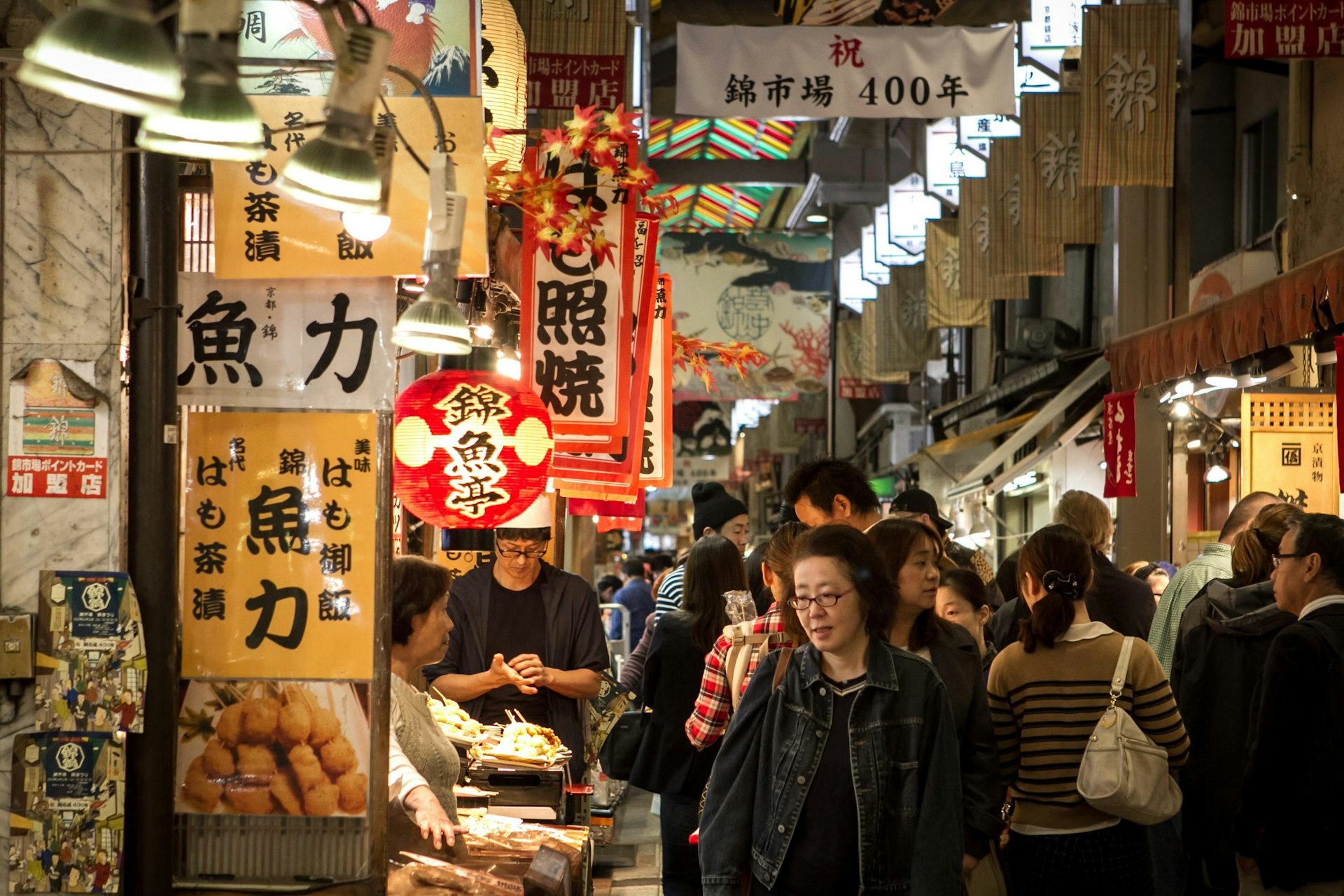 People in the famous Nishiki Market in Kyoto, Japan with Japanese signage