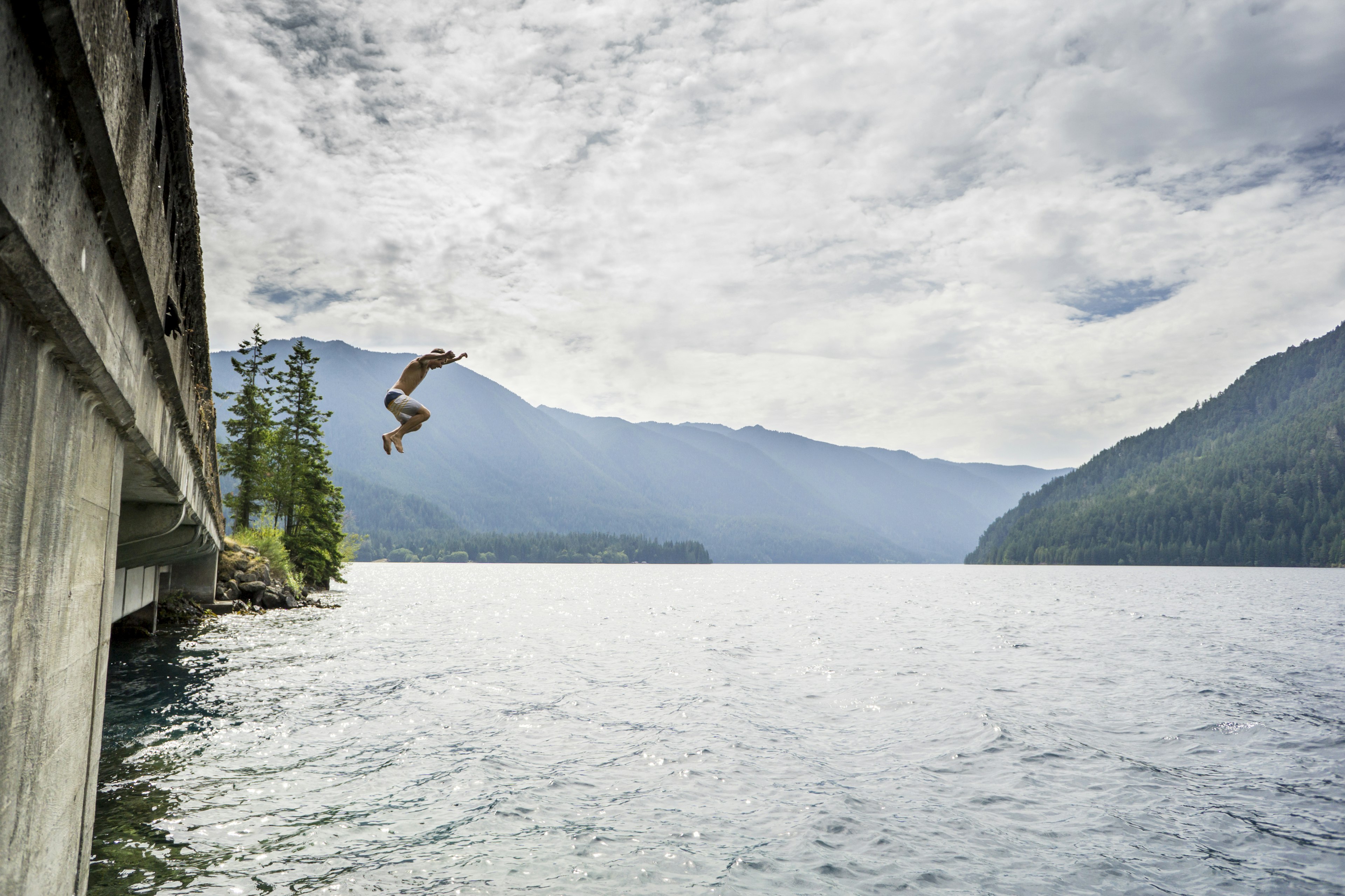 A man jumping from a bridge in the Olympic National Park.