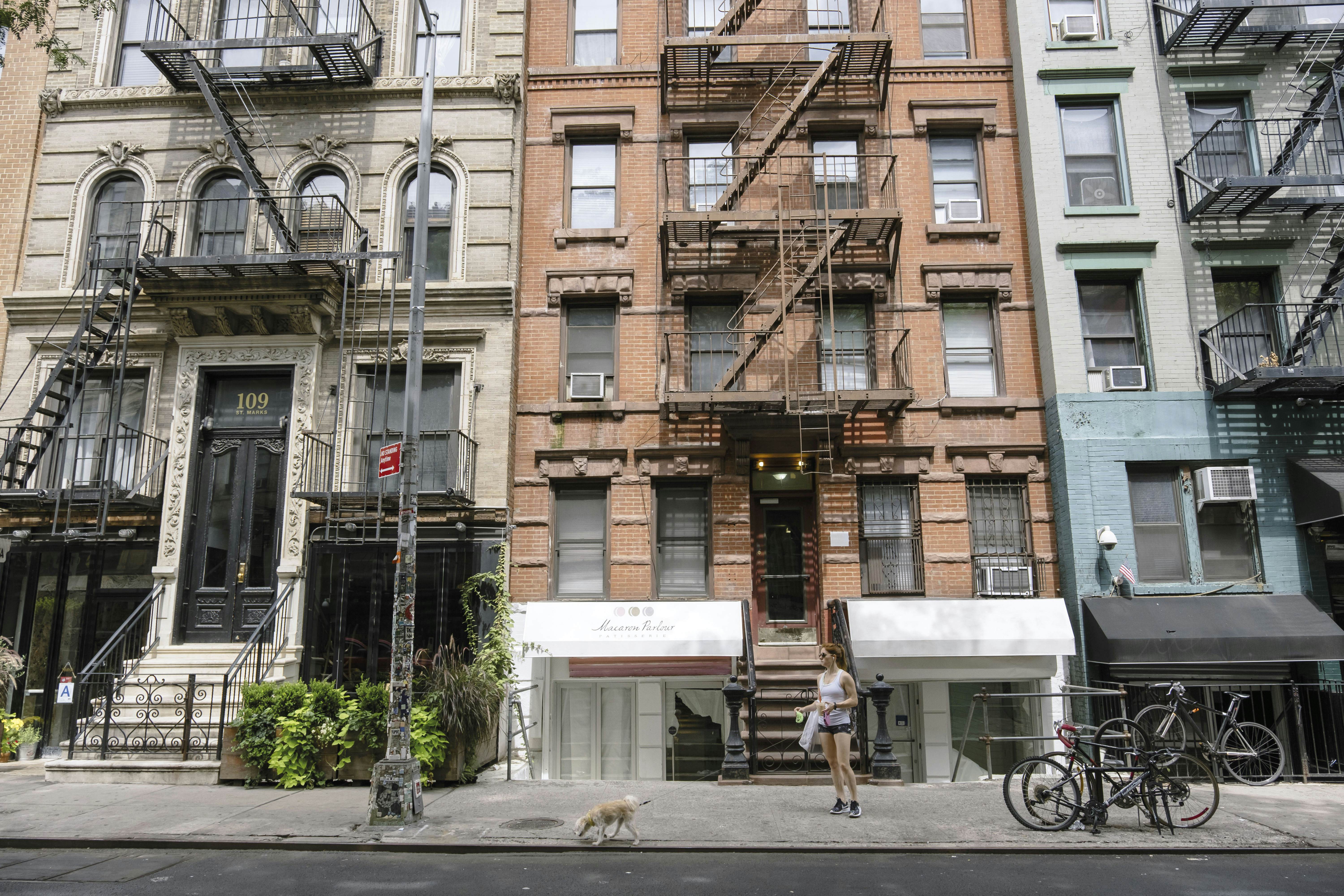 A woman walks a dog on St Mark’s Place (8th St) in Manhatten's East Village.