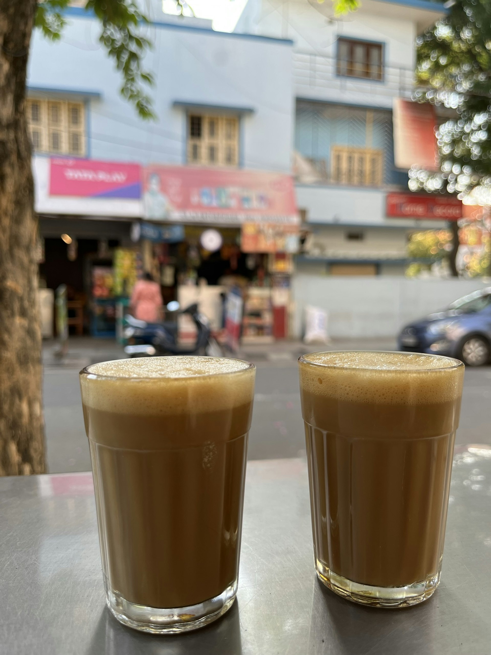 Two filter coffees served in glasses at an outside table