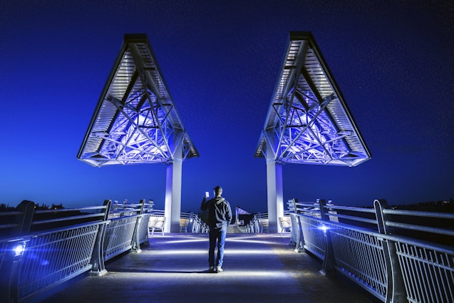 Man walking on Terwillegar Bridge in Edmonton, Alberta.
