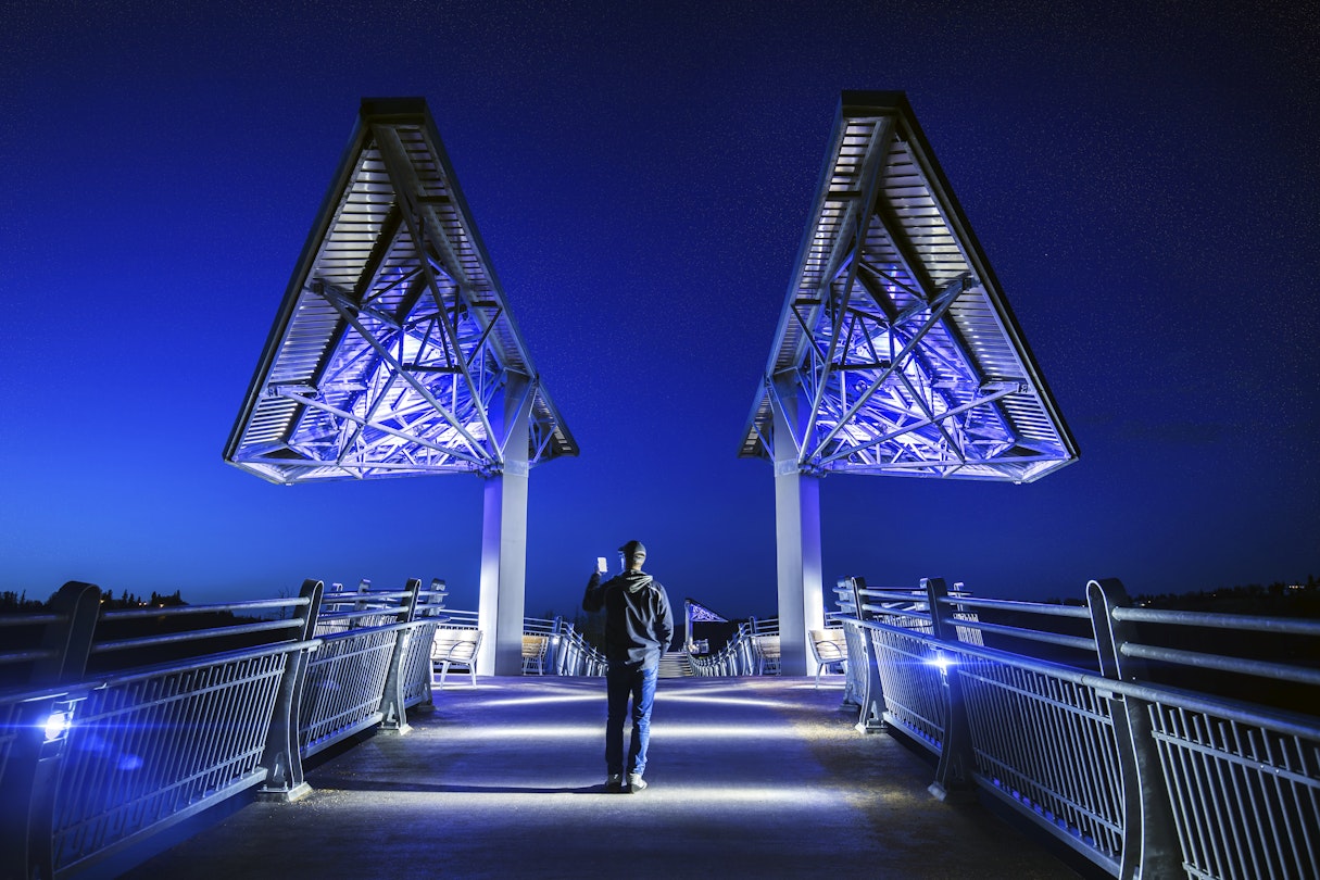 Man walking on Terwillegar Bridge in Edmonton, Alberta.