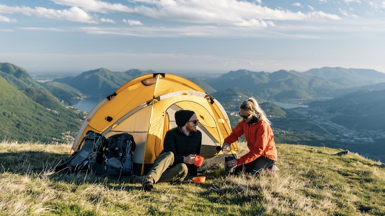 Camping adventure at sunset and sunrise in the mountains above city and lake
1150320394