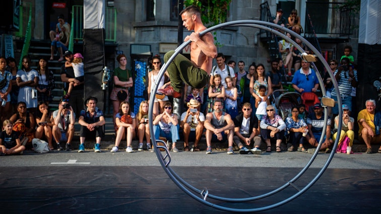 cThe crowd watches as people perform during "The Minutes" at the Montreal Cirque Festival on July 14, 2019 in Montreal, Quebec, where  thirty-two acrobats took over the street for a travelling performance. (Photo by Sebastien St-Jean / AFP)        (Photo credit should read SEBASTIEN ST-JEAN/AFP via Getty Images)
1159554503
Horizontal, CIRCUS FESTIVAL