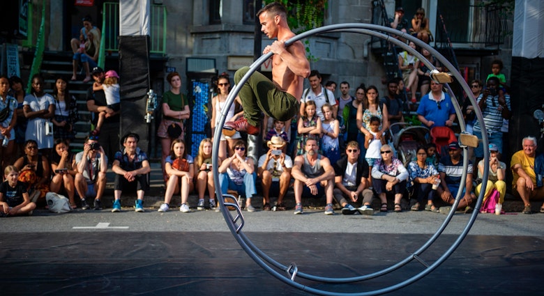 cThe crowd watches as people perform during "The Minutes" at the Montreal Cirque Festival on July 14, 2019 in Montreal, Quebec, where  thirty-two acrobats took over the street for a travelling performance. (Photo by Sebastien St-Jean / AFP)        (Photo credit should read SEBASTIEN ST-JEAN/AFP via Getty Images)
1159554503
Horizontal, CIRCUS FESTIVAL
