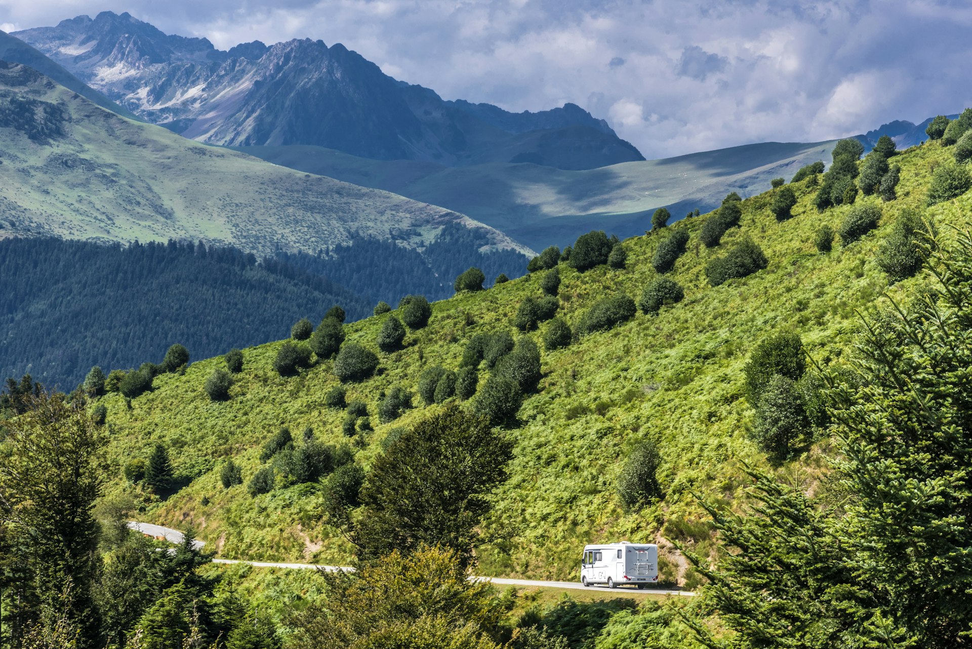 A camper drives along a road in the French Pyrenees