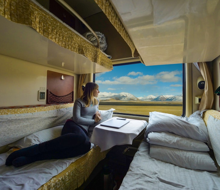 Young woman lies on the bed and looks through the window of the sleeper train crossing picturesque Tibet. Female tourist observing the landscape while travelling along the Trans-Himalayan railway.
1185025359
woman, train, himalaya, lying, bed, sleeper, class, overnight train, private, train car, first, traveler, traveling, cabin, view, vista, beautiful, stunning, plains, observing, sight, trans-himalayan railway, panorama, scenery, landscape, relax, rest, young, caucasian, female, countryside, ride, explore, trip, lifestyle, wagon, vacation