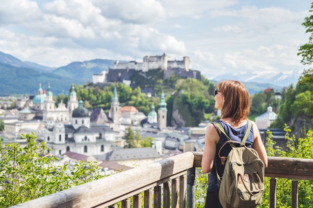 Holiday in Salzburg: Young girl is enjoying the view. Historic district, Festung Hohensalzburg. Female tourist is enjoying the view over the historic district of Salzburg © Patrick Daxenbichler / Getty Images