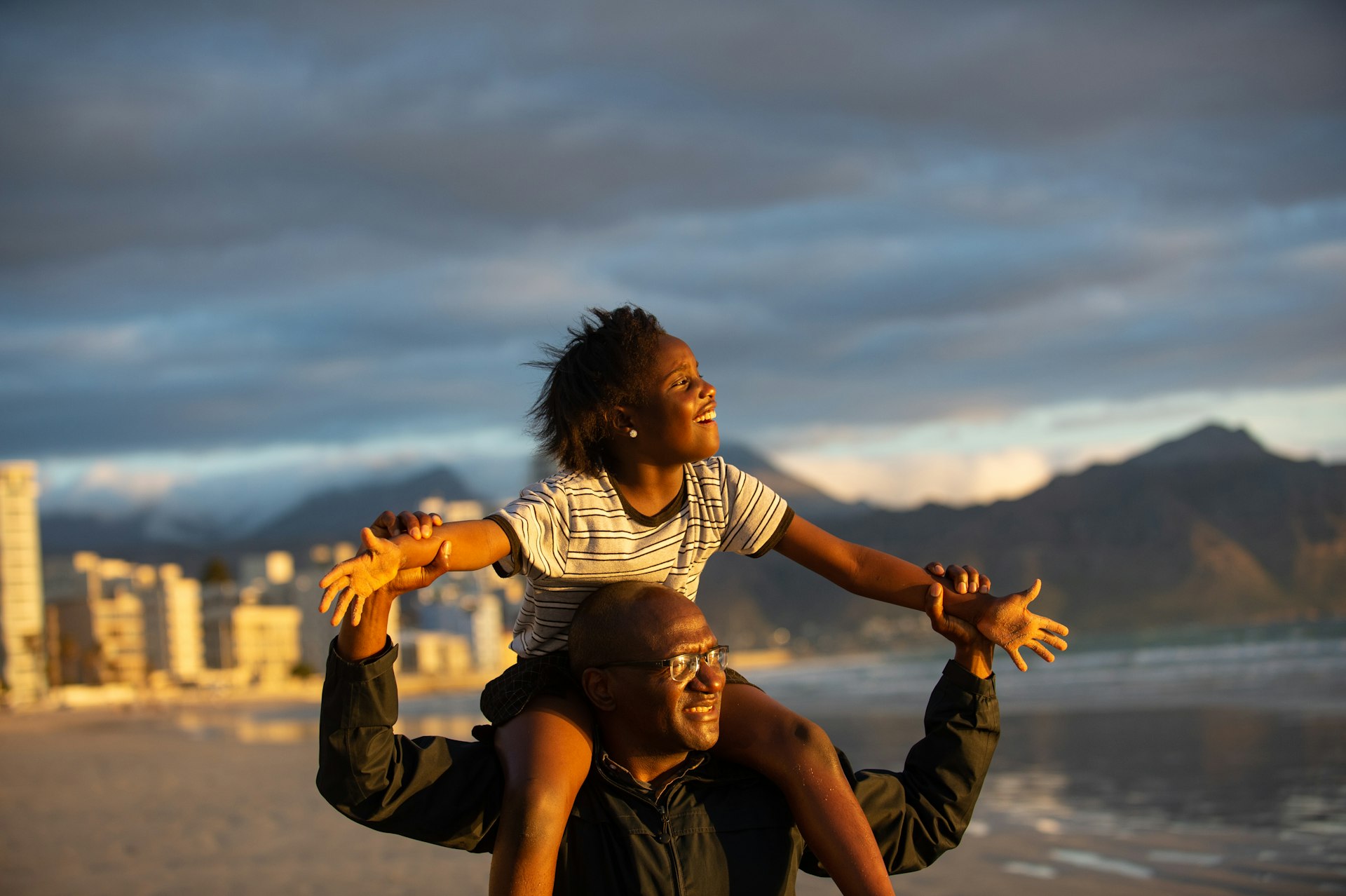 A girl and her father on the beach in a city in South Africa