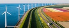A daytime view of wind turbines in the sea and colourful tulips from a high viewpoint
1297835710