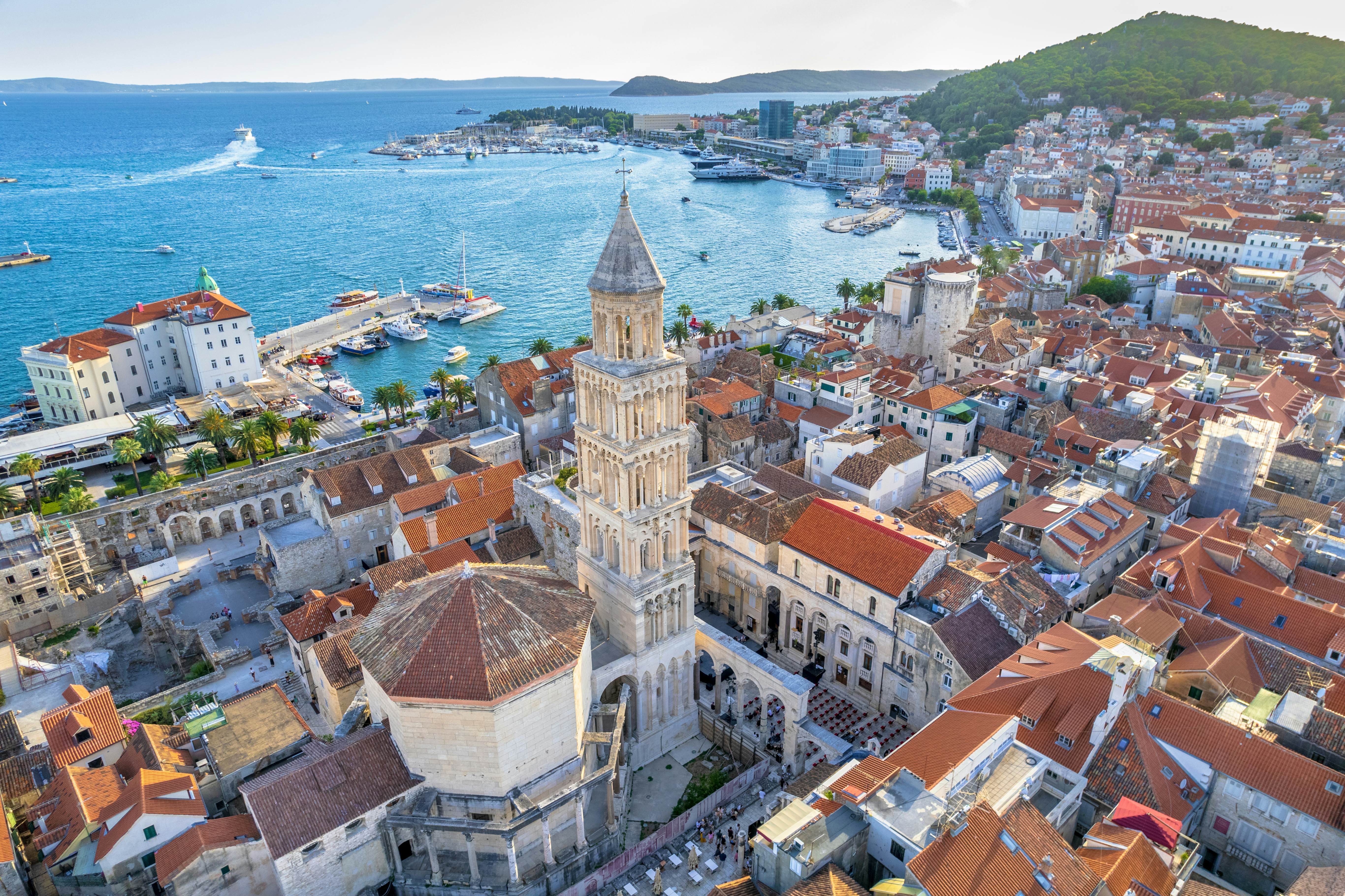 An ancient town center with a tall bell tower beside the sea