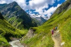 A group hiking in the valley Of Umbalfaelle On Grossvenediger With View To Mountain Roetspitze In Nationalpark Hohe Tauern In Tirol In Austria