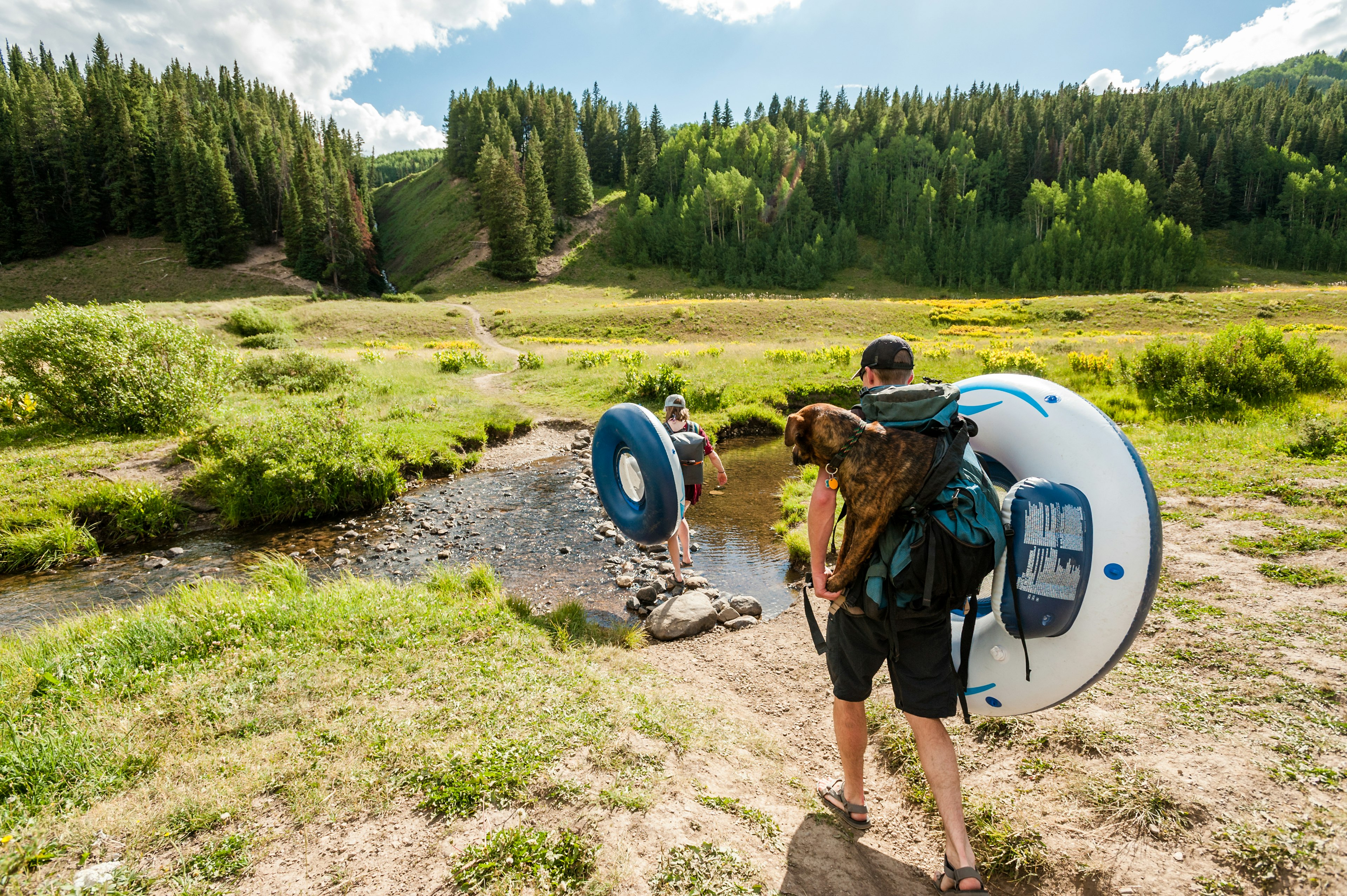 A couple carries water tubes to a lake near Crested Butte, Colorado