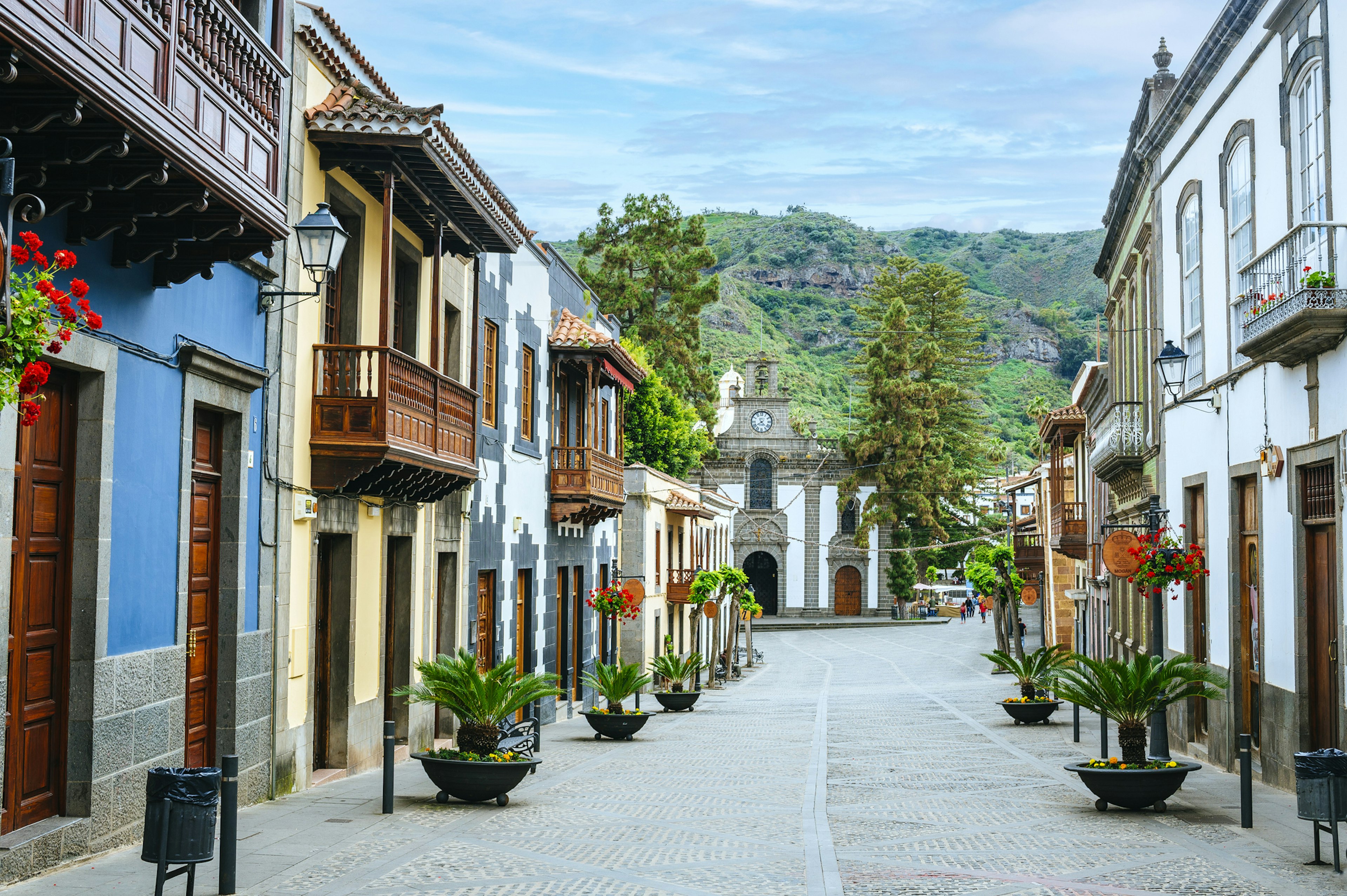 A row of colorful houses leading down a street to a small church