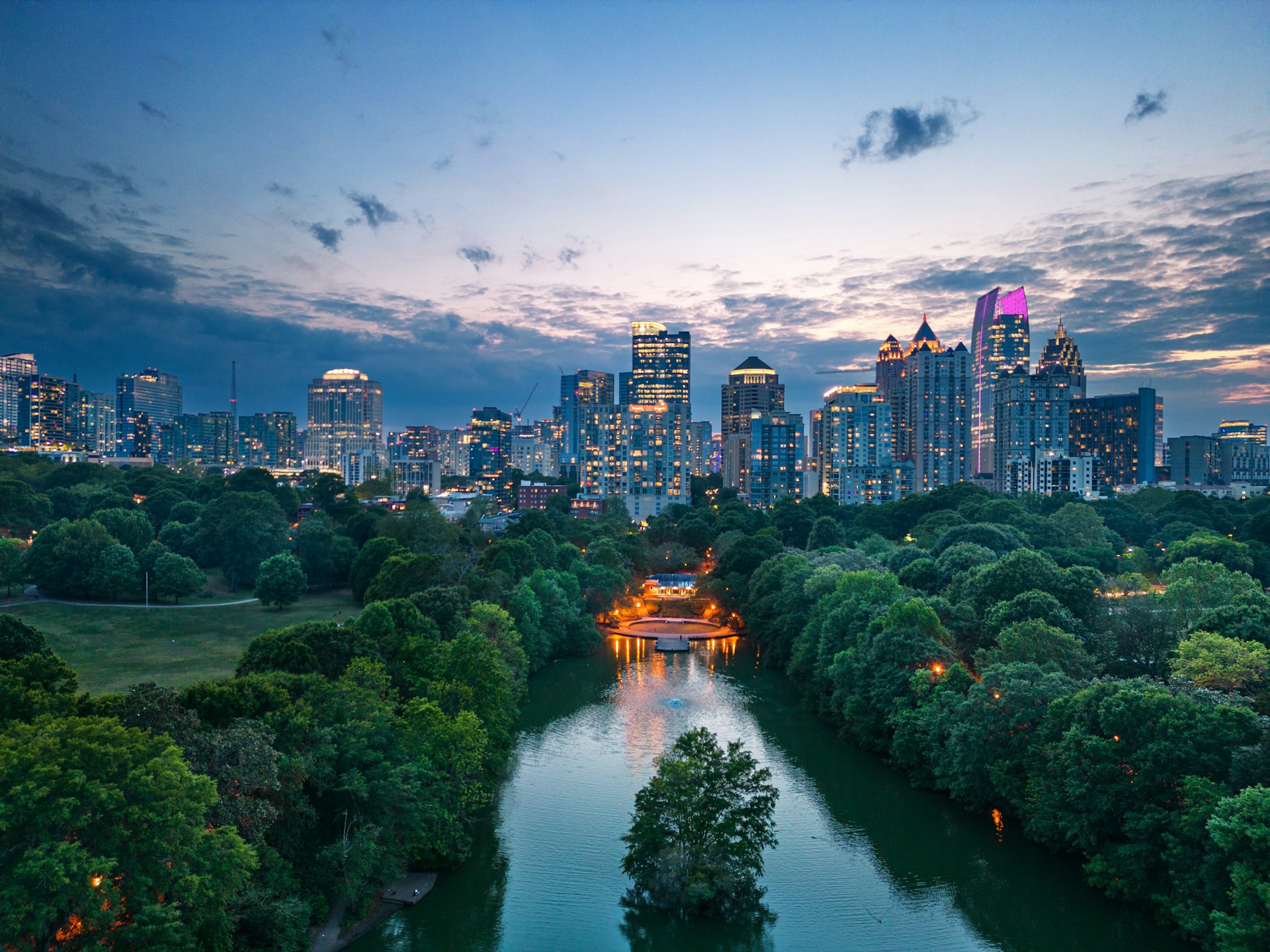 An aerial shot of Piedmont Park at dusk, with the skyline of downtown Atlanta in the distance, Atlanta, Georgia, USA