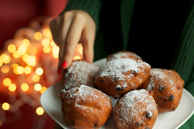 Traditional Dutch New Year's Eve pastry - oliebollen, woman picking one donut, bokeh lights background
170054565
© Ira Heuvelman-Dobrolyubova / Getty Images