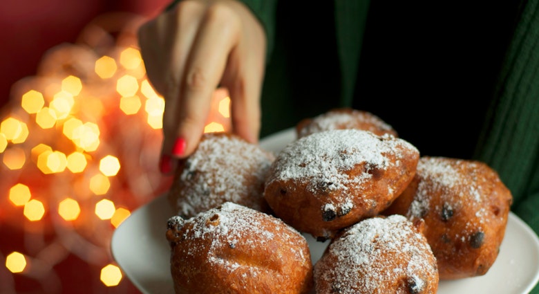 Traditional Dutch New Year's Eve pastry - oliebollen, woman picking one donut, bokeh lights background
170054565
© Ira Heuvelman-Dobrolyubova / Getty Images